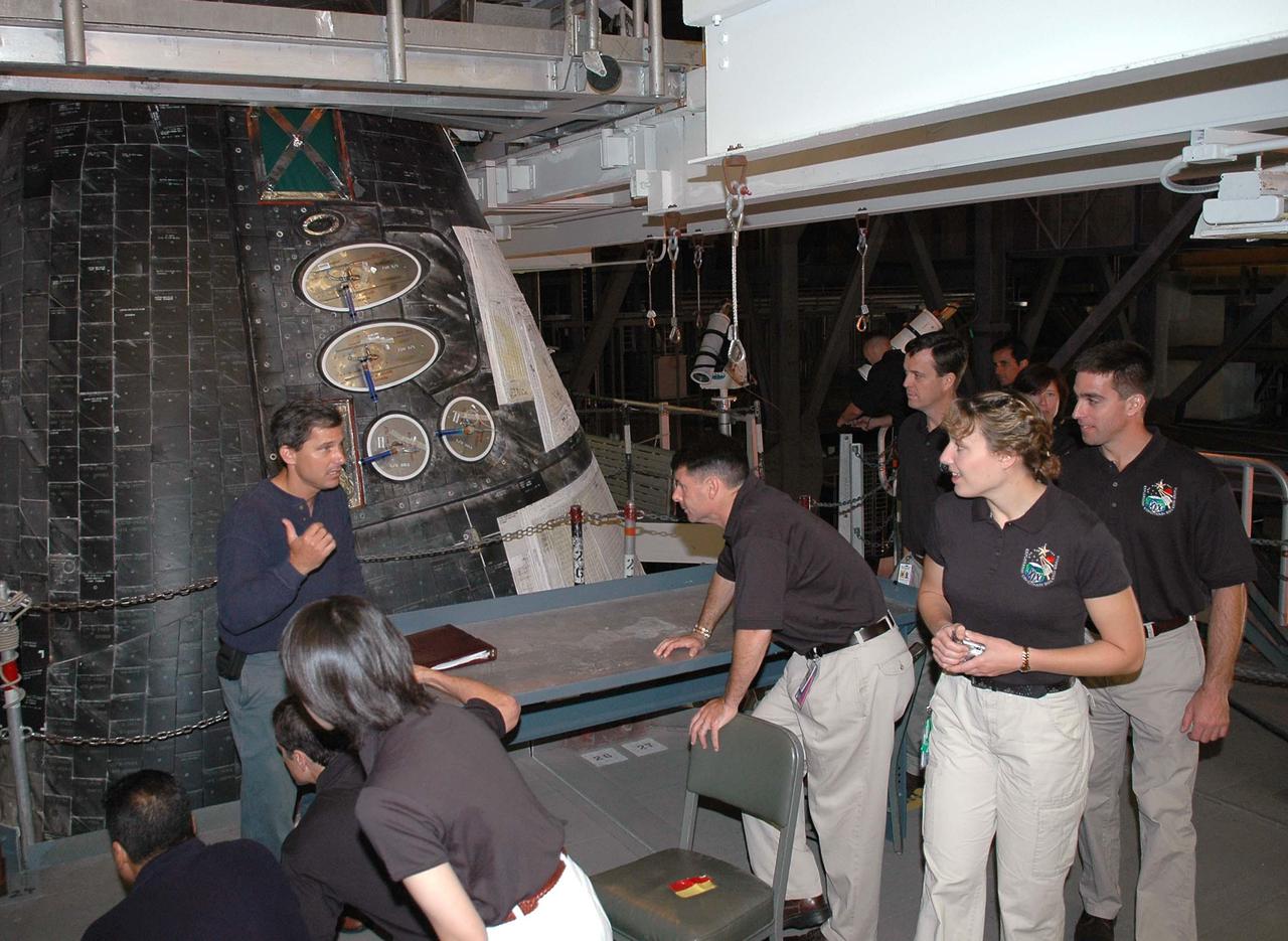 KENNEDY SPACE CENTER, FLA. -  At NASA’s Kennedy Space Center, the 2004 class of astronaut candidates get a close look  at the Forward Reaction Control System on Space Shuttle Discovery in the Vehicle Assembly Building (VAB).  Talking to them at left is Ken Tenbusch, VAB Operations manager. The class of 14 candidates includes three candidates from the Japan Aerospace Exploration Agency as well as three educator astronauts, who were school teachers chosen from thousands of applicants.