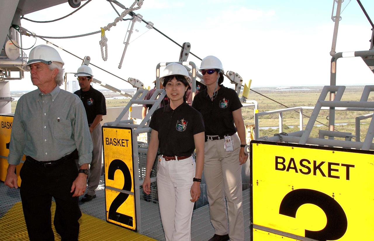 KENNEDY SPACE CENTER, FLA. -  At NASA’s Kennedy Space Center, the 2004 class of astronaut candidates tour Launch Pad 39B, where Space Shuttle Discovery will launch on Return to Flight mission STS-114 during a launch window of May 15 to June 3.  Two class members, Naoko Yamnazaki (left) and Shannon Walker (right), get a look at the emergency egress system, the slidewire baskets, on the Fixed Service Structure.  The class of 14 candidates includes three candidates from the Japan Aerospace Exploration Agency as well as three educator astronauts, who were school teachers chosen from thousands of applicants.