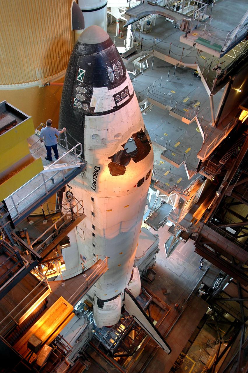 KENNEDY SPACE CENTER, FLA. -  In the Vehicle Assembly Building (VAB) at NASA’s Kennedy Space Center, Space Shuttle Discovery begins its long, slow journey to Launch Pad 39B.  First motion was at 2:04 p.m. EDT.  The Shuttle comprises the orbiter, External Tank (ET) and twin Solid Rocket Boosters (SRBs). The Space Shuttle rests on the Mobile Launcher Platform, which is moved by the Crawler-Transporter underneath.  The Crawler is 20 feet high, 131 feet long and 114 feet wide.  It moves on eight tracks, each containing 57 shoes, or cleats, weighing one ton each.  Loaded with the Space Shuttle, the Crawler can move at a maximum speed of approximately 1 mile an hour. A leveling system in the Crawler keeps the Shuttle vertical while negotiating the 5 percent grade leading to the top of the launch pad.  Launch of Discovery on its Return to Flight mission, STS-114, is targeted for May 15 with a launch window that extends to June 3. During its 12-day mission, Discovery’s seven-person crew will test new hardware and techniques to improve Shuttle safety, as well as deliver supplies to the International Space Station.  Discovery was moved on March 29 from the Orbiter Processing Facility to the VAB and attached to its propulsion elements, a redesigned ET and twin SRBs.