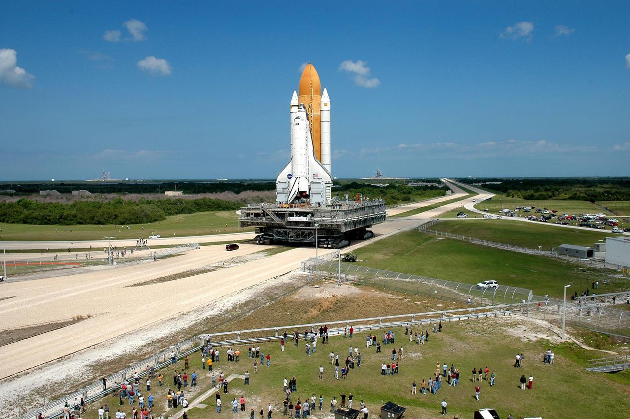 KENNEDY SPACE CENTER, FLA. -  The broad, brilliant blue Florida sky silhouettes Space Shuttle Discovery as it creeps along the crawlerway toward the horizon, and Launch Pad 39B at NASA’s Kennedy Space Center.  First motion of the Shuttle out of the Vehicle Assembly Building (VAB)  was at 2:04 p.m. EDT.  The Mobile Launcher Platform is moved by the Crawler-Transporter underneath.  The Crawler is 20 feet high, 131 feet long and 114 feet wide.  It moves on eight tracks, each containing 57 shoes, or cleats, weighing one ton each.  Loaded with the Space Shuttle, the Crawler can move at a maximum speed of approximately 1 mile an hour. A leveling system in the Crawler keeps the Shuttle vertical while negotiating the 5 percent grade leading to the top of the launch pad.  Launch of Discovery on its Return to Flight mission, STS-114, is targeted for May 15 with a launch window that extends to June 3. During its 12-day mission, Discovery’s seven-person crew will test new hardware and techniques to improve Shuttle safety, as well as deliver supplies to the International Space Station.  Discovery was moved on March 29 from the Orbiter Processing Facility to the VAB and attached to its propulsion elements, a redesigned ET and twin SRBs.