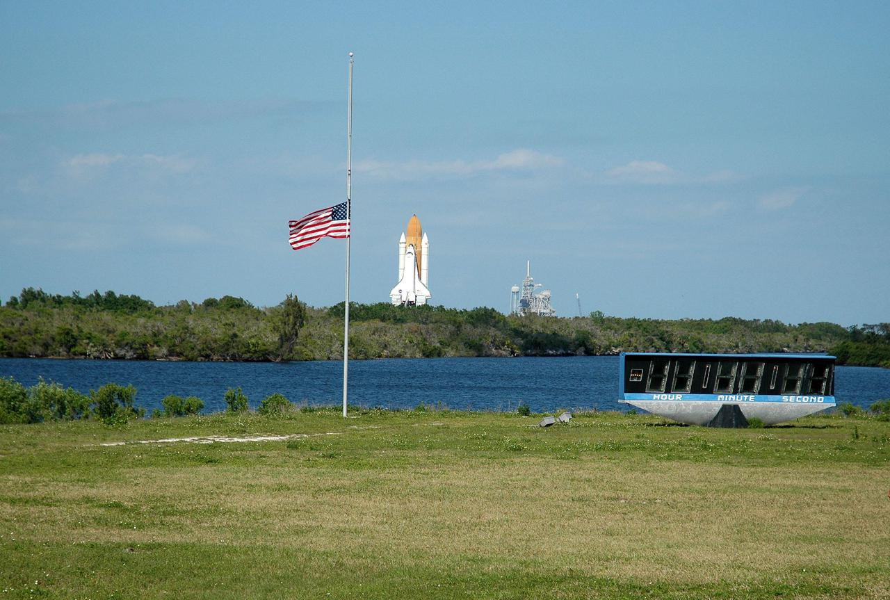 KENNEDY SPACE CENTER, FLA. -   A KSC employee stands at the Press Site watching Space Shuttle Discovery mark a major milestone for Return to Flight, rolling out to Launch Pad 39B.  First motion out of the Vehicle Assembly Building was at 2:04 p.m. EDT. The Shuttle sits atop the Mobile Launcher Platform, which is moved by the Crawler-Transporter underneath.  The Crawler is 20 feet high, 131 feet long and 114 feet wide.  It moves on eight tracks, each containing 57 shoes, or cleats, weighing one ton each.  Loaded with the Space Shuttle, the Crawler can move at a maximum speed of approximately 1 mile an hour. A leveling system in the Crawler keeps the Shuttle vertical while negotiating the 5 percent grade leading to the top of the launch pad.  Launch of Discovery on its Return to Flight mission, STS-114, is targeted for May 15 with a launch window that extends to June 3. During its 12-day mission, Discovery’s seven-person crew will test new hardware and techniques to improve Shuttle safety, as well as deliver supplies to the International Space Station.  Discovery was moved on March 29 from the Orbiter Processing Facility to the VAB and attached to its propulsion elements, a redesigned ET and twin SRBs.