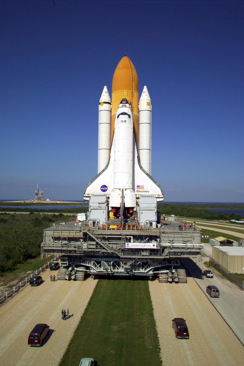 KENNEDY SPACE CENTER, FLA. -   At NASA’s Kennedy Space Center, Space Shuttle Discovery, atop the Mobile Launcher Platform (MLP), crawls toward Launch Complex 39B. First motion out of the Vehicle Assembly Building occurred at 2:04 p.m. EDT.  The rollout marks a major milestone in the Space Shuttle Program’s Return to Flight. The MLP is moved by the Crawler-Transporter underneath, which stands 20 feet high, 131 feet long and 114 feet wide.  It moves on eight tracks, each containing 57 shoes, or cleats, weighing one ton each.  Loaded with the Space Shuttle, the Crawler can move at a maximum speed of approximately 1 mile an hour. A leveling system in the Crawler keeps the Shuttle vertical while negotiating the 5 percent grade leading to the top of the launch pad.  Launch of Discovery on its Return to Flight mission, STS-114, is targeted for May 15 with a launch window that extends to June 3. During its 12-day mission, Discovery’s seven-person crew will test new hardware and techniques to improve Shuttle safety, as well as deliver supplies to the International Space Station.