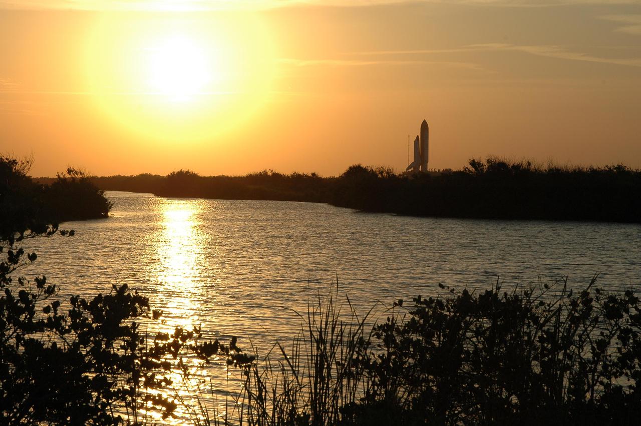KENNEDY SPACE CENTER, FLA.  -   The orange glow of the setting sun paints a silhouette of Space Shuttle Discovery (on the right) as it rolls out to Launch Pad 39B at NASA’s Kennedy Space Center.  The Shuttle began rollout to the pad at 2:04 p.m. EDT from the Vehicle Assembly Building at NASA’s Kennedy Space Center, marking a major milestone in the Space Shuttle Program’s Return to Flight.   Launch of Discovery on its Return to Flight mission, STS-114, is targeted for May 15 with a launch window that extends to June 3. During its 12-day mission, Discovery’s seven-person crew will test new hardware and techniques to improve Shuttle safety, as well as deliver supplies to the International Space Station.