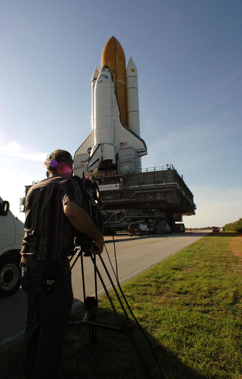 KENNEDY SPACE CENTER, FLA. -  KSC-TV videographer Jack Pfaller of InDyne, Inc., captures Space Shuttle Discovery as it rolls along the crawlerway from the Vehicle Assembly Building to Launch Pad 39B.  First motion began at 2:04 p.m. EDT April 6, and the Shuttle was hard down on the pad at 1:16 a.m. EDT April 7. The Shuttle sits atop the Mobile Launcher Platform and is transported by the Crawler-Transporter underneath. Launch of Discovery on its Return to Flight mission, STS-114, is targeted for May 15 with a launch window that extends to June 3. During its 12-day mission, Discovery’s seven-member crew will test new hardware and techniques to improve Shuttle safety, as well as deliver supplies to the International Space Station.