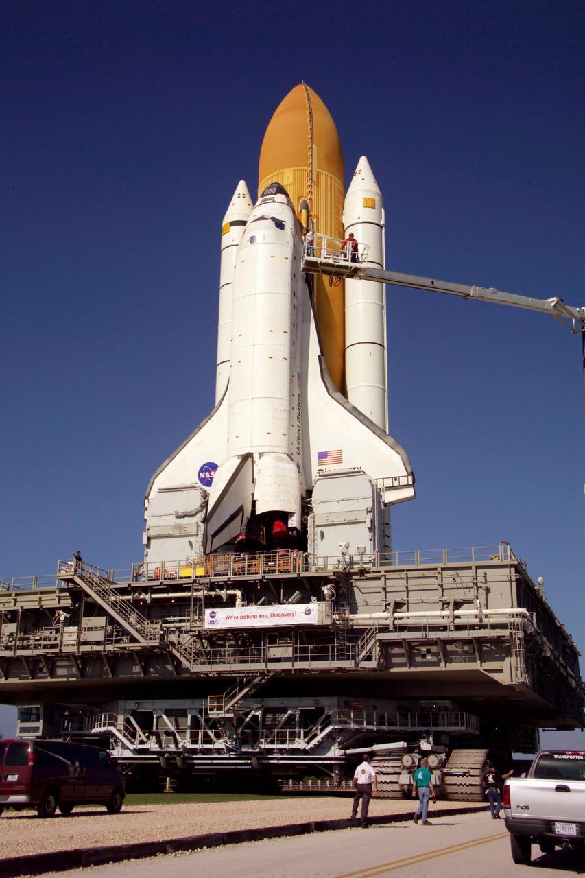 KENNEDY SPACE CENTER, FLA. - Technicians photograph the exterior of Space Shuttle Discovery on its journey to Launch Pad 39B to support the Baseline Configuration Imaging (BCI) project.  BCI will be collected on each orbiter prior to every mission, beginning with STS-114.  The photos will be compiled into a database available for comparison, if the need arises, to photos taken on orbit from the Shuttle's Orbital Boom Sensor System (OBSS).  The 50-foot-long OBSS attaches to the Remote Manipulator System, or Shuttle robotic arm, and is one of the new safety measures for Return to Flight, equipping the orbiter with cameras and laser systems to inspect the Shuttle’s Thermal Protection System while in space. Discovery was hard down on the pad at 1:16 a.m. EDT April 7. Launch of Discovery on its Return to Flight mission, STS-114, is targeted for May 15 with a launch window that extends to June 3. During its 12-day mission, Discovery’s seven-member crew will test new hardware and techniques to improve Shuttle safety, as well as deliver supplies to the International Space Station.