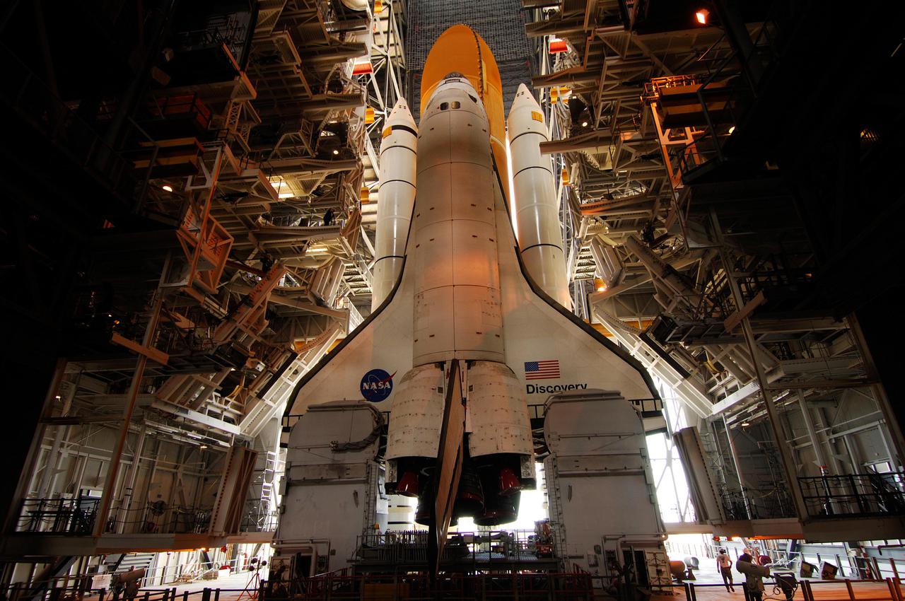 KENNEDY SPACE CENTER, FLA. - Daylight entering through the open doors of the Vehicle Assembly Building (VAB) illuminates the Space Shuttle Discovery in the high bay where it was mated to its External Tank (ET) and twin Solid Rocket Boosters (SRBs). First motion on its long, slow journey to Launch Pad 39B was at 2:04 p.m. EDT.  The Space Shuttle rests on a Mobile Launcher Platform, which is moved by a Crawler-Transporter underneath. Loaded with the Space Shuttle, the Crawler can move at a maximum speed of approximately 1 mile an hour. Launch of Discovery on its Return to Flight mission, STS-114, is targeted for May 15 with a launch window that extends to June 3. During its 12-day mission, Discovery’s seven-member crew will test new hardware and techniques to improve Shuttle safety, as well as deliver supplies to the International Space Station. Photo courtesy of Scott Andrews.