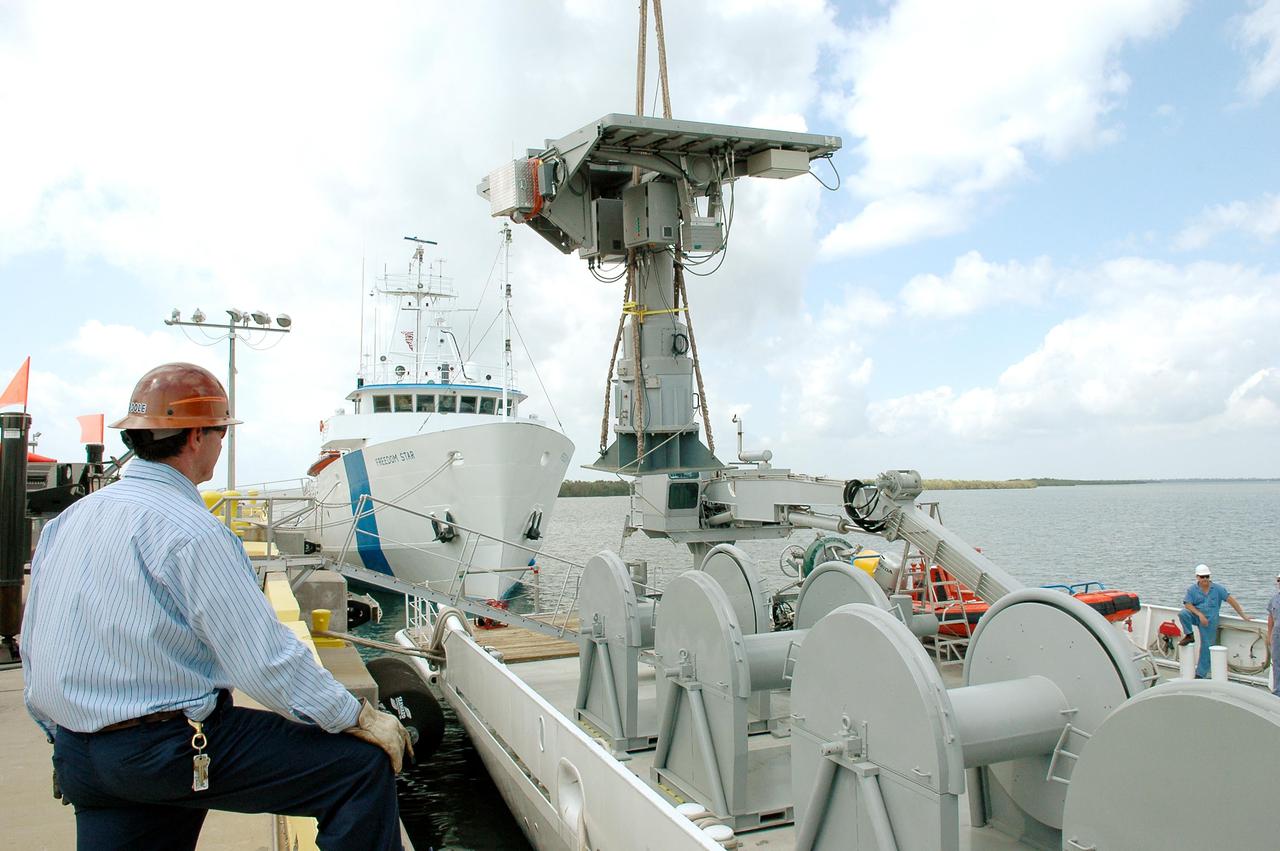 KENNEDY SPACE CENTER, FLA. - An X-band Doppler radar array is lowered toward the deck of the Liberty Star,  one of the two SRB Retrieval Ships, at Hangar AF at Cape Canaveral Air Force Station.  The other retrieval ship, Freedom Star, is aft of the Liberty Star. The radar will be used for tracking support on NASA’s Return to Flight mission, STS-114, on Space Shuttle Discovery.  Launch is targeted for May 15 with a launch window that extends to June 3. During its 12-day mission, Discovery’s seven-member crew will test new hardware and techniques to improve Shuttle safety, as well as deliver supplies to the International Space Station.
