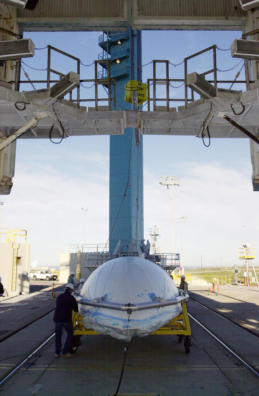 VANDENBERG AIR FORCE BASE, CALIF. - On Space Launch Complex 2 at Vandenberg Air Force Base in California, one of the two fairing sections for the National Oceanic and Atmospheric Administration (NOAA-N) spacecraft arrives at the launch service tower where it will be lifted to an upper level.  The fairing will be placed around the spacecraft to protect it during launch. NOAA-N is the fourth in the series of support dedicated microwave instruments for the generation of temperature, moisture, surface, and hydrological products in cloudy regions where visible and infrared (IR) instruments have decreased capability.  Launch aboard a Boeing Delta II rocket is currently scheduled for no earlier than May 11, 2005.
