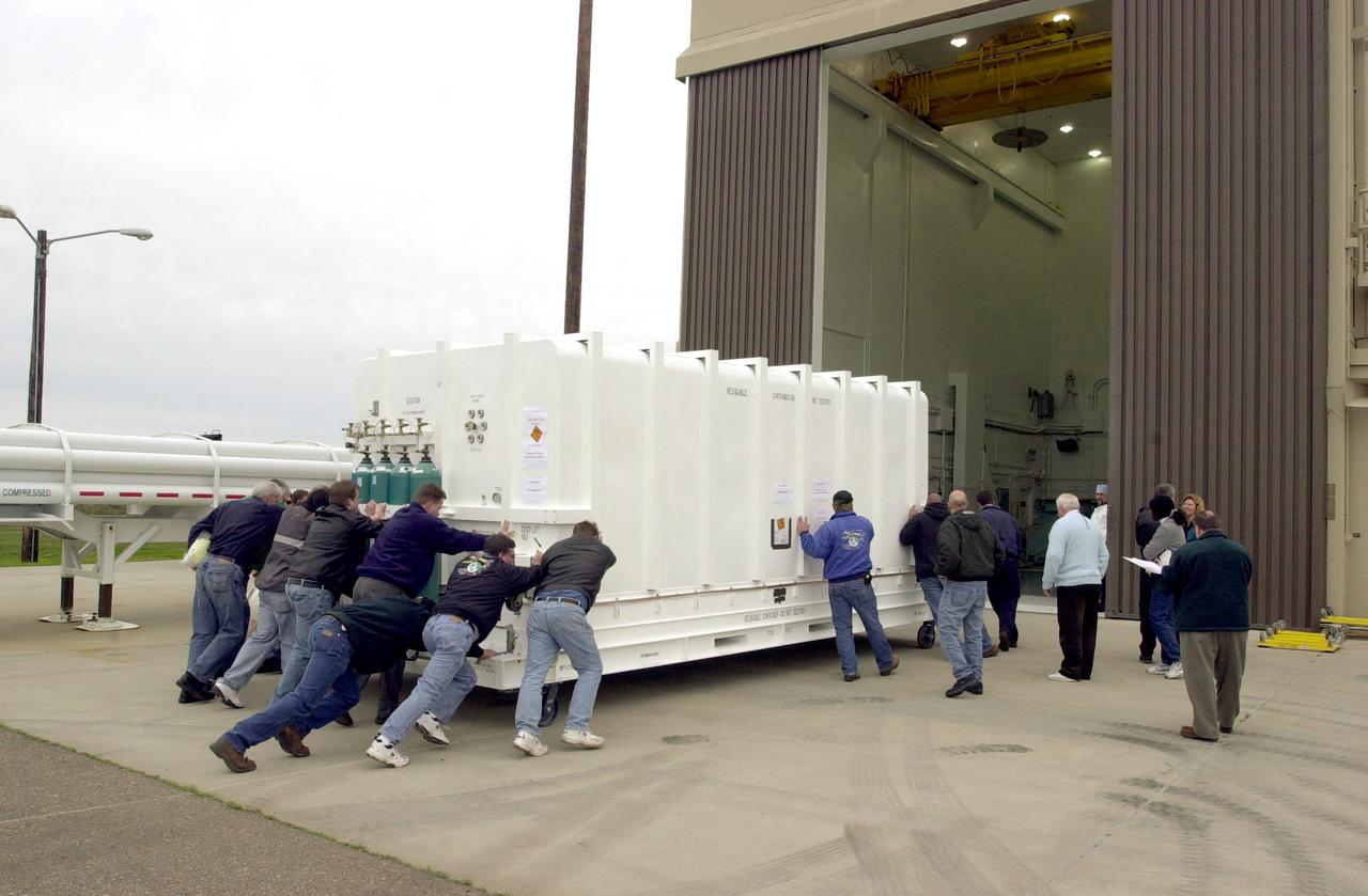VANDENBERG AIR FORCE BASE, CALIF. - At Vandenberg Air Force Base in California, workers move the National Oceanic and Atmospheric Administration (NOAA-N) spacecraft into a hangar where it will undergo preflight processing.  The NOAA-N satellite will be placed into a polar orbit aboard a Boeing Delta 2 rocket.  The spacecraft will continue to provide a polar-orbiting platform to support (1) environmental monitoring instruments for imaging and measuring the Earth's atmosphere, its surface, and cloud cover, including Earth radiation, atmospheric ozone, aerosol distribution, sea surface temperature, and vertical temperature and water profiles in the troposphere and stratosphere; (2) measurement of proton and electron flux at orbit altitude; (3) data collection from remote platforms; and (4) the Search and Rescue Satellite-Aided Tracking (SARSAT) system.  Additionally, NOAA-N is the fourth in the series of support dedicated microwave instruments for the generation of temperature, moisture, surface, and hydrological products in cloudy regions where visible and infrared (IR) instruments have decreased capability.  Launch is currently scheduled for no earlier than May 11, 2005.