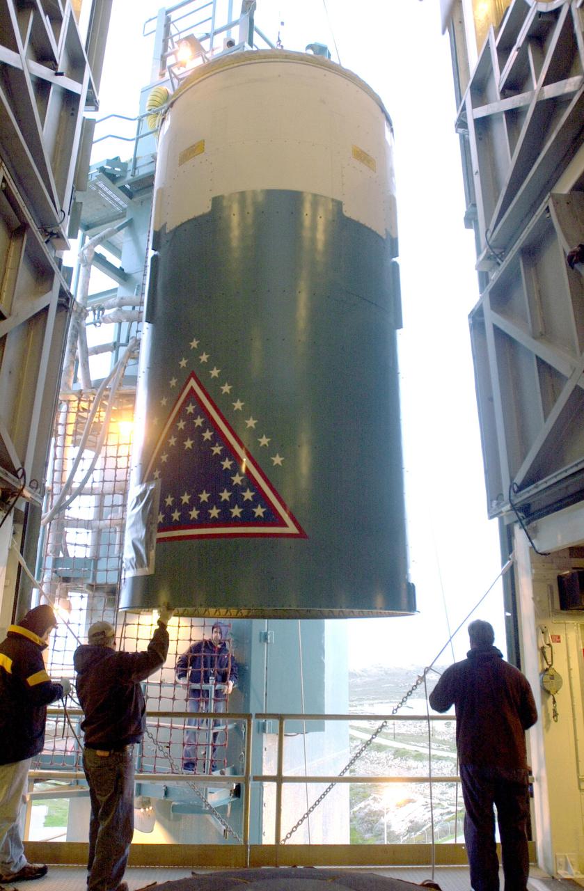 VANDENBERG AIR FORCE BASE, CALIF. - At an upper level of the launch service tower on Space Launch Complex 2 at Vandenberg Air Force Base in California, workers help guide the interstage of a Boeing Delta 2 rocket inside.  It will be mated with the first stage in the launch service tower for launch of the National Oceanic and Atmospheric Administration (NOAA-N) spacecraft. The NOAA-N satellite will be placed into a polar orbit aboard a Boeing Delta 2 rocket.  The spacecraft will continue to provide a polar-orbiting platform to support (1) environmental monitoring instruments for imaging and measuring the Earth's atmosphere, its surface, and cloud cover, including Earth radiation, atmospheric ozone, aerosol distribution, sea surface temperature, and vertical temperature and water profiles in the troposphere and stratosphere; (2) measurement of proton and electron flux at orbit altitude; (3) data collection from remote platforms; and (4) the Search and Rescue Satellite-Aided Tracking (SARSAT) system.  Additionally, NOAA-N is the fourth in the series of support dedicated microwave instruments for the generation of temperature, moisture, surface, and hydrological products in cloudy regions where visible and infrared (IR) instruments have decreased capability.  Launch is currently scheduled for no earlier than May 11, 2005.
