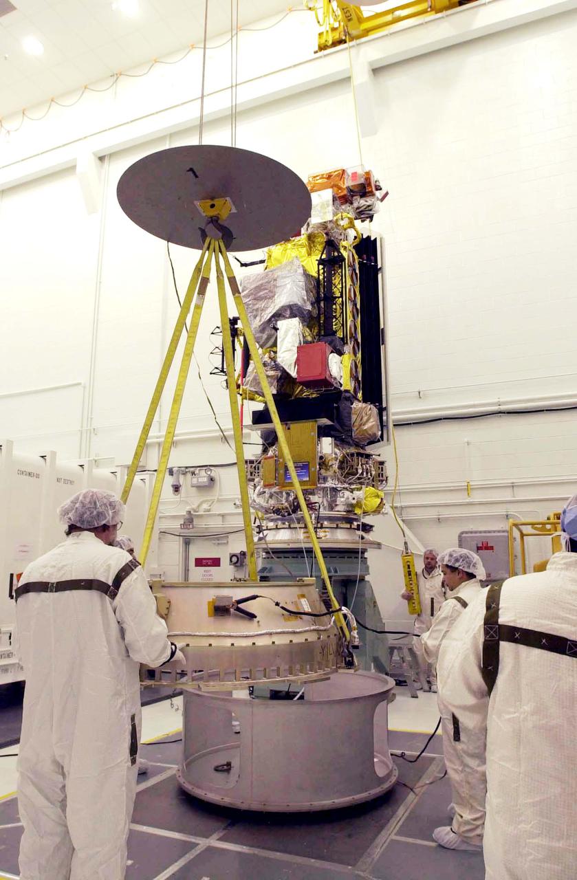 VANDENBERG AIR FORCE BASE, CALIF. - Inside the NASA spacecraft processing hangar 1610 located on North Vandenberg Air Force Base in California,  Lockheed Martin workers maneuver the Boeing Delta II payload attach fitting onto a connecting ring on the floor.  The National Oceanic and Atmospheric Administration (NOAA-N) spacecraft, in the background, will then be mated to the payload attach fitting.  Launch of NOAA-N aboard the Boeing Delta II rocket is currently scheduled for May 11, 2005.  NOAA-N is the fourth in the series of support dedicated microwave instruments for the generation of temperature, moisture, surface, and hydrological products in cloudy regions where visible and infrared (IR) instruments have decreased capability.