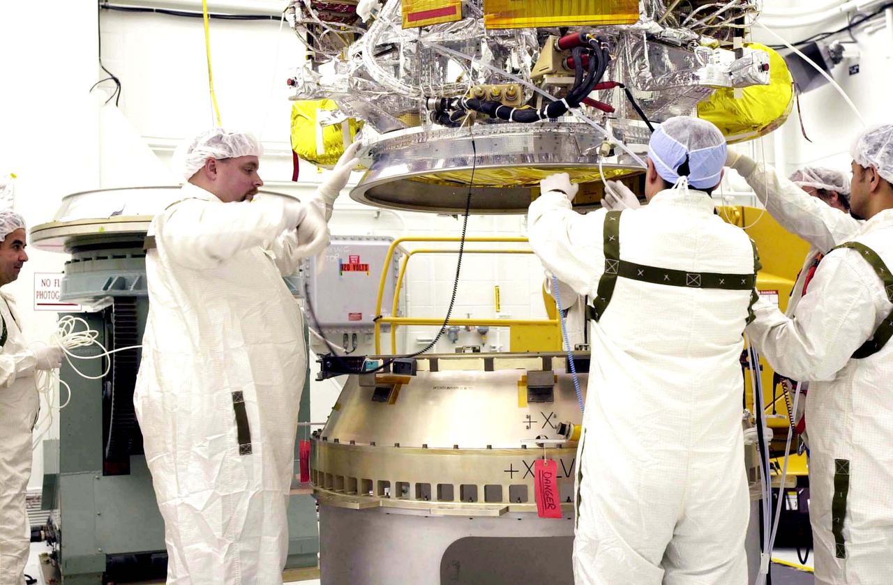 VANDENBERG AIR FORCE BASE, CALIF. - Inside the NASA spacecraft processing hangar 1610 located on North Vandenberg Air Force Base in California,  Lockheed Martin workers help guide the National Oceanic and Atmospheric Administration (NOAA-N) spacecraft, above, onto the Boeing Delta II payload attach fitting below.   Launch of NOAA-N aboard the Boeing Delta II rocket is currently scheduled for May 11, 2005.  NOAA-N is the fourth in the series of support dedicated microwave instruments for the generation of temperature, moisture, surface, and hydrological products in cloudy regions where visible and infrared (IR) instruments have decreased capability.