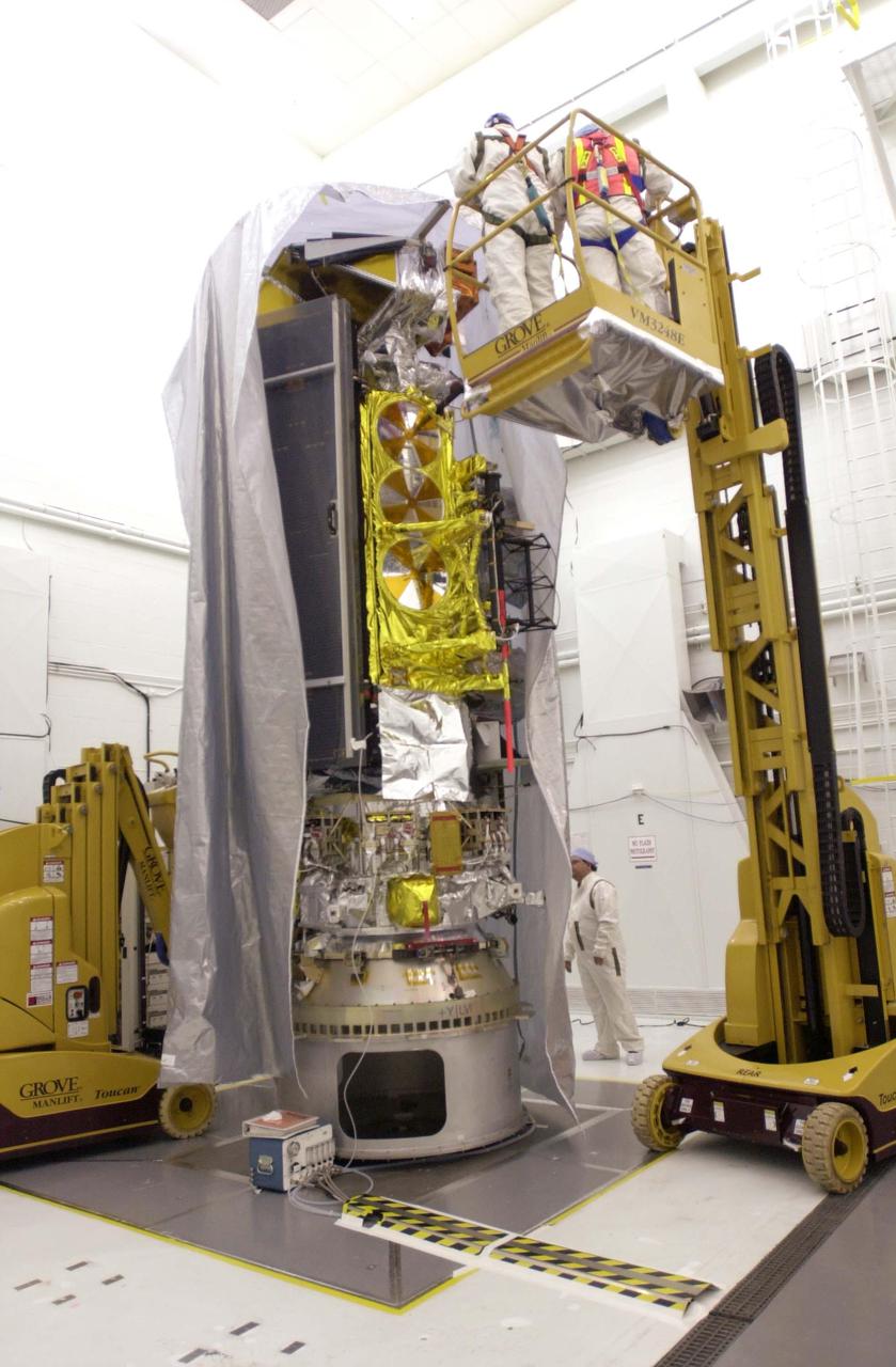 VANDENBERG AIR FORCE BASE, CALIF. - Inside the NASA spacecraft processing hangar 1610 located on North Vandenberg Air Force Base in California, Lockheed Martin workers place a protective cover around the National Oceanic and Atmospheric Administration (NOAA-N) spacecraft.  Mechanical and electrical ground support equipment will be set up and the necessary connections made with the spacecraft.   Launch of NOAA-N aboard the Boeing Delta II rocket is currently scheduled for May 11, 2005.  NOAA-N is the fourth in the series of support dedicated microwave instruments for the generation of temperature, moisture, surface, and hydrological products in cloudy regions where visible and infrared (IR) instruments have decreased capability.