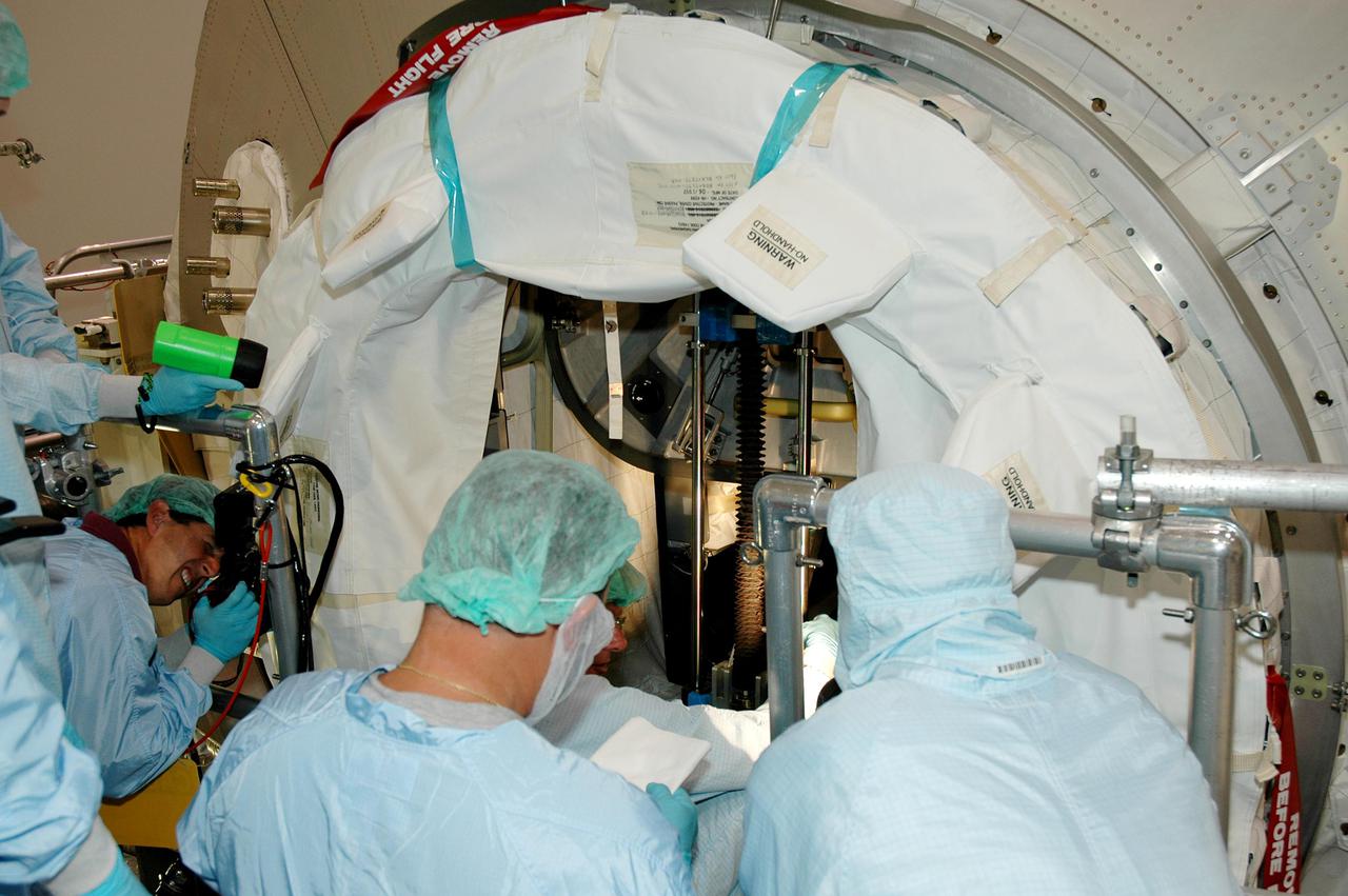KENNEDY SPACE CENTER, FLA. -- Workers in the Space Station Processing Facility take final measurements flight on Italian-built Multi-Purpose Logistics Module Raffaello as they prepare to close the hatch for flight, a significant milestone on the road to Return to Flight.   The module will travel to the International Space Station aboard Space Shuttle Discovery’s Return to Flight mission STS-114.  Raffaello carries 12 racks of cargo, including food, clothing, spare parts and research equipment, to the Station.  Shuttle Discovery is targeted for launch in a window extending May 15 through June 3.