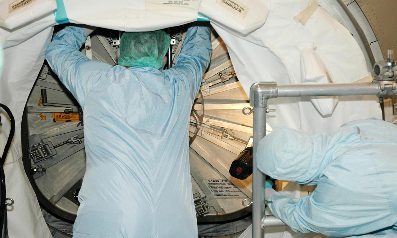 KENNEDY SPACE CENTER, FLA. -- Workers in the Space Station Processing Facility close the hatch for flight on Italian-built Multi-Purpose Logistics Module Raffaello, a significant milestone on the road to Return to Flight.    The module will travel to the International Space Station aboard Space Shuttle Discovery’s Return to Flight mission STS-114.  Raffaello carries 12 racks of cargo, including food, clothing, spare parts and research equipment, to the Station.  Shuttle Discovery is targeted for launch in a window extending May 15 through June 3.