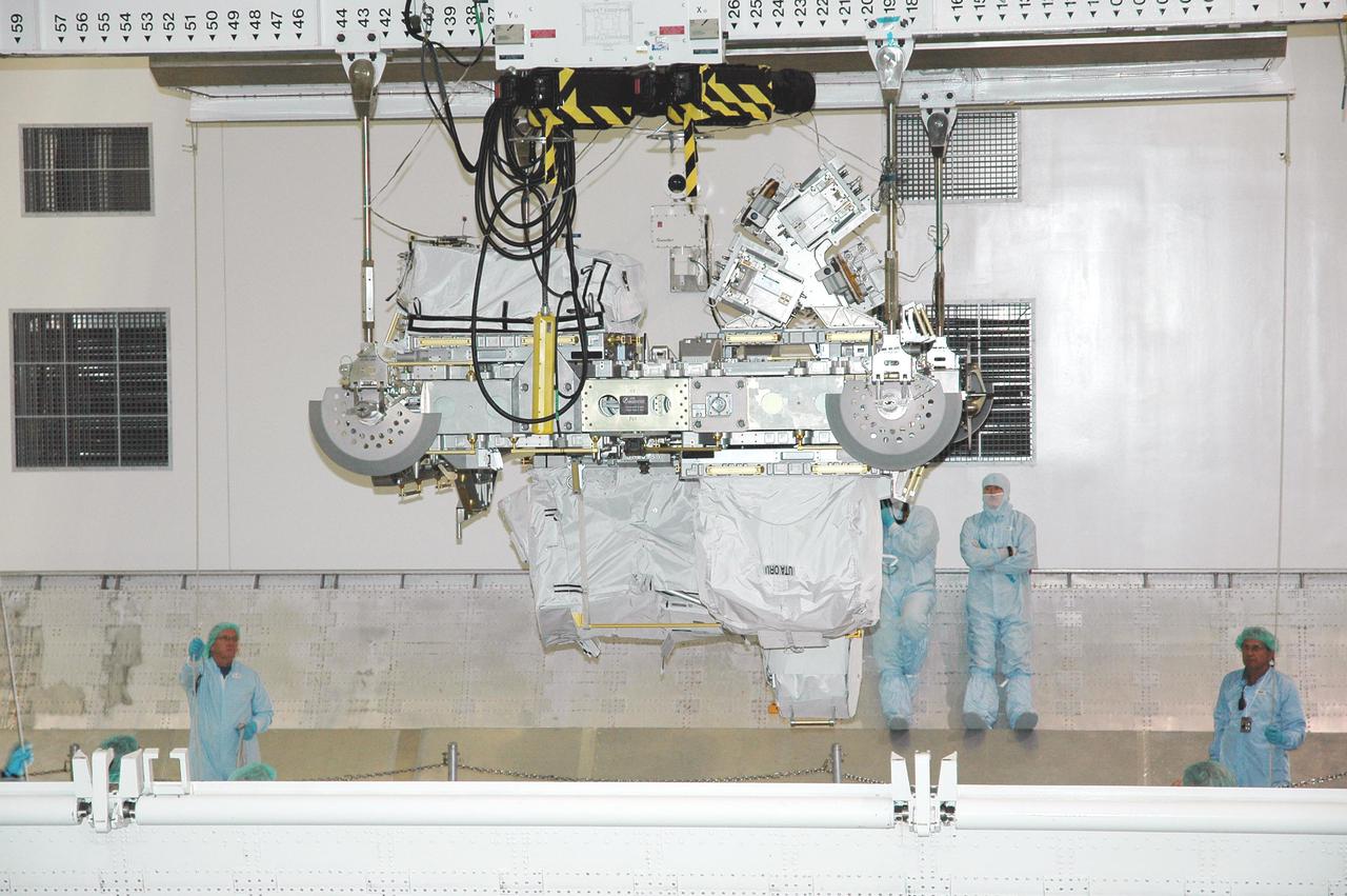 KENNEDY SPACE CENTER, FLA. - In the Space Station Processing Facility, the CELA (Cargo Element Lifting Assembly) carrying the External Stowage Platform-2 launching aboard Space Shuttle Discovery on Return to Flight mission STS-114 stops above the payload canister. The ESP-2 will travel to Launch Pad 39B with its fellow payload elements the Lightweight MPESS Carrier (Multi-Purpose Experiment Support Structure) and Multi-Purpose Logistics Module Raffaello in the canister. Once at the pad, the three payloads will be transferred to the payload bay of Discovery for flight. The ESP-2 is carrying replacement parts to the International Space Station. The platform will be deployed and attached to the Station’s airlock and used as a permanent spare parts facility. STS-114 is targeted for launch during a window that extends from May 15 through June 3.