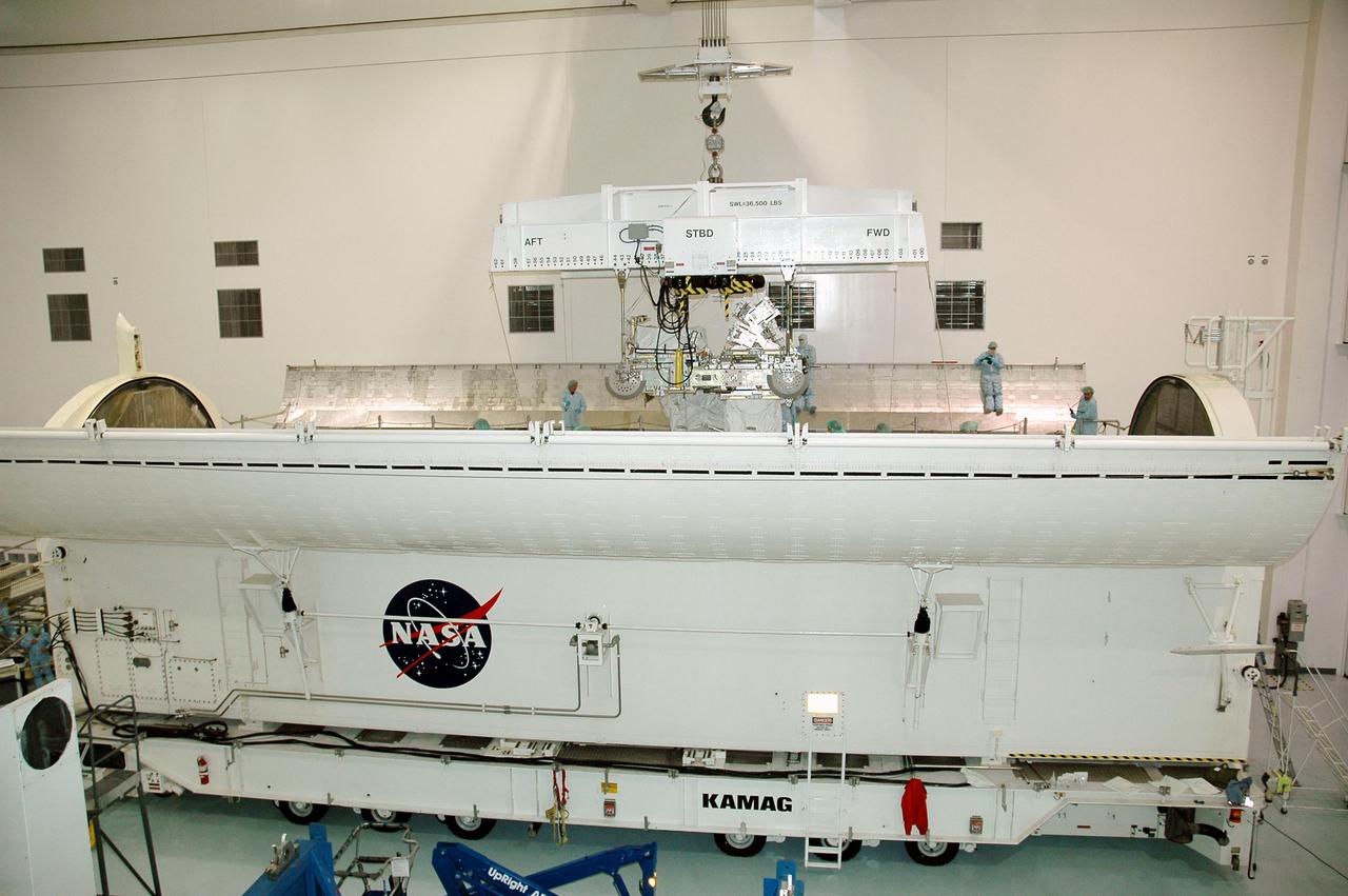 KENNEDY SPACE CENTER, FLA. -In the Space Station Processing Facility, the CELA (Cargo Element Lifting Assembly) lowers the External Stowage Platform-2 (ESP-2) into the payload canister. The ESP-2 will travel to Launch Pad 39B with its fellow payload elements the Lightweight MPESS Carrier (Multi-Purpose Experiment Support Structure) and Multi-Purpose Logistics Module Raffaello in the canister. Once at the pad, the three payloads will be transferred to the payload bay of Discovery for flight. The ESP-2 is carrying replacement parts to the International Space Station. The platform will be deployed and attached to the Station’s airlock and used as a permanent spare parts facility. STS-114 is targeted for launch during a window that extends from May 15 through June 3.