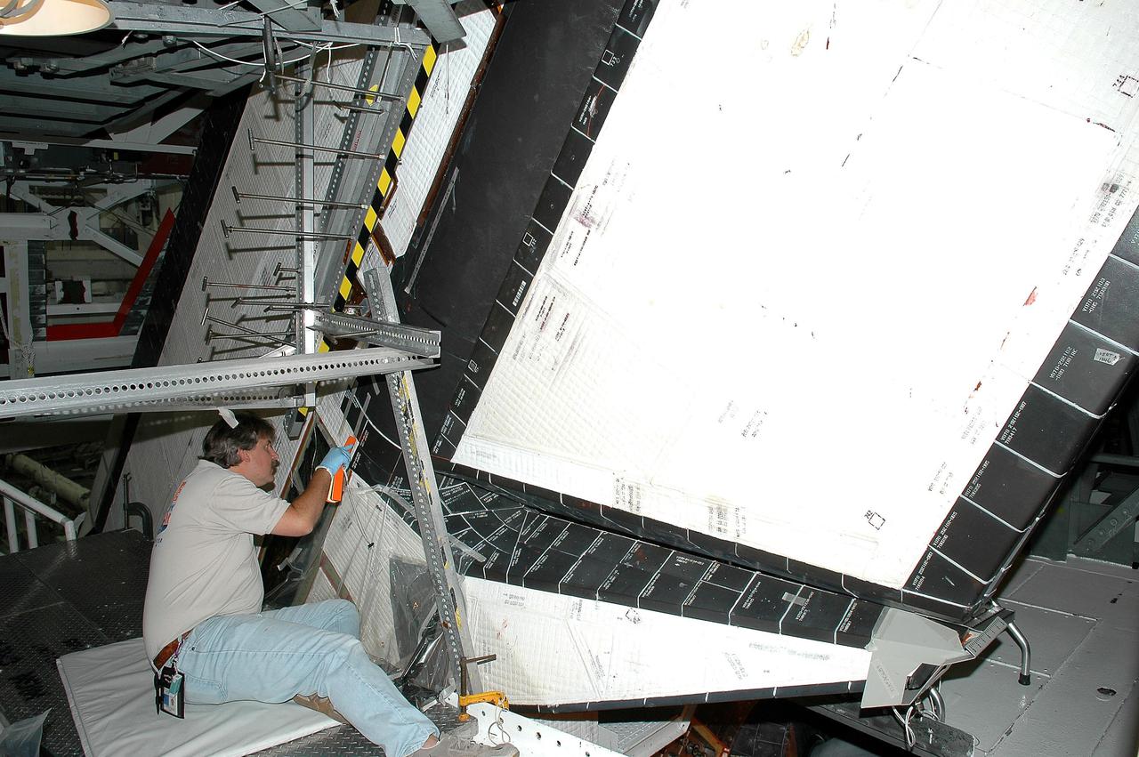 KENNEDY SPACE CENTER, FLA. - In the Orbiter Processing Facility at NASA’s Kennedy Space Center, United Space Alliance tile technician Tim Marks places Thermal Protection System tiles on Atlantis’ rudder speed brake. Atlantis is being processed for launch on the second Return to Flight mission, STS-121, which is scheduled to fly in July.