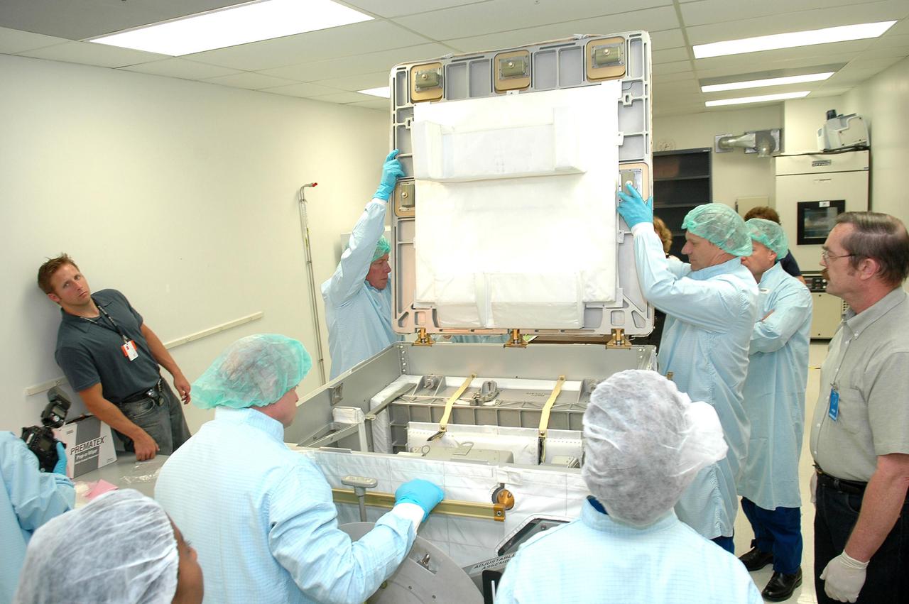 KENNEDY SPACE CENTER, FLA. - Mission Specialists Michael E. Fossum (left) and Piers J. Sellers, Ph.D., (right) open the SPACEHAB Oceaneering Enhanced Deployable box. Looking on are Mission Specialist Stephanie D. Wilson, Pilot Mark E. Kelly, Mission Specialist Lisa M. Nowak and Commander Steven W. Lindsey. The astronauts of the second Return to Flight mission, STS-121, were at the SPACEHAB facility in Cape Canaveral to participate in the Crew Equipment Interface Test (CEIT). This test allows the astronauts to become familiar with equipment they will be using on their upcoming mission. STS-121 is scheduled to launch in July aboard Space Shuttle Atlantis.