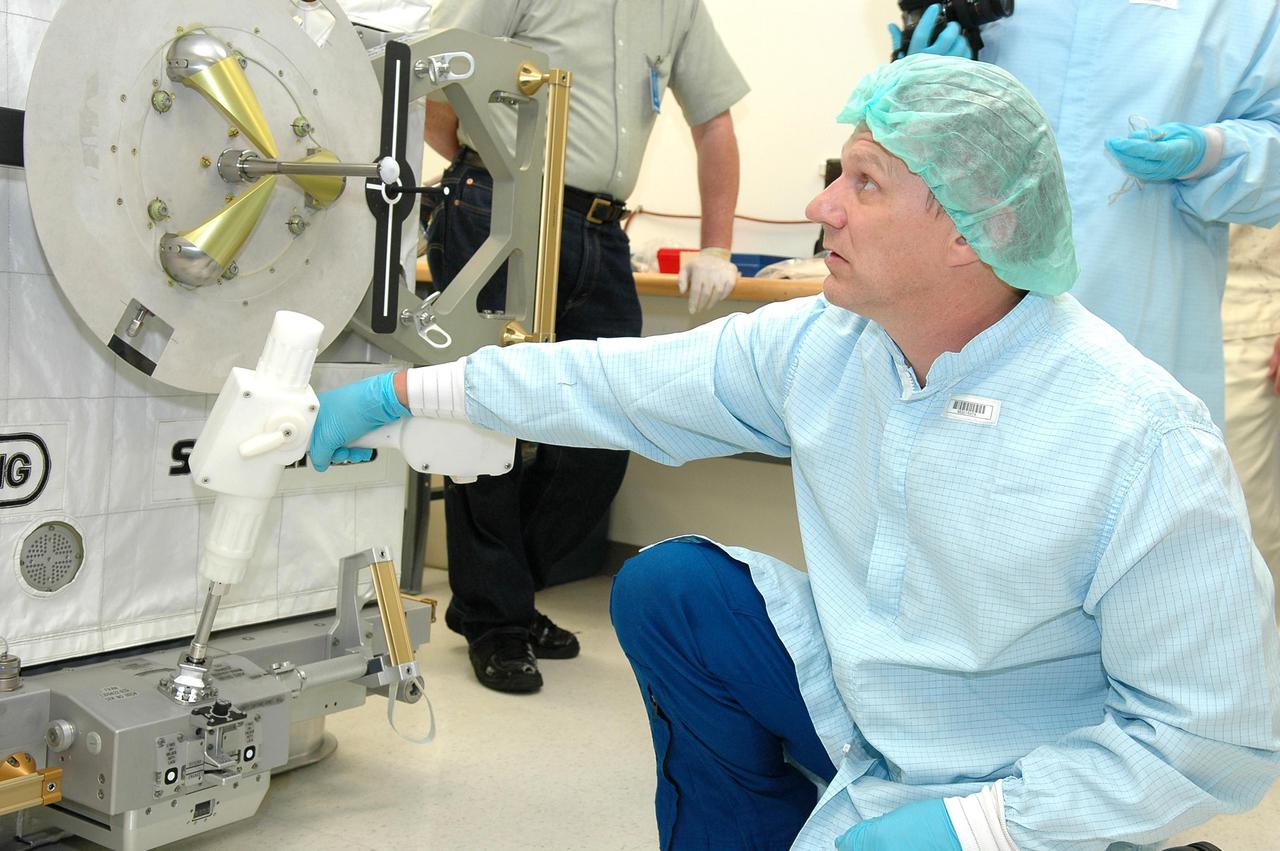 KENNEDY SPACE CENTER, FLA. - Mission Specialist Piers J. Sellers, Ph.D., checks out the release mechanism on the SPACEHAB Oceneering Enhanced Deployable FRAM. The astronauts of the second Return to Flight mission, STS-121, were at the SPACEHAB facility in Cape Canaveral to participate in the Crew Equipment Interface Test (CEIT). This test allows the astronauts to become familiar with equipment they will be using on their upcoming mission. STS-121 is scheduled to launch in July aboard Space Shuttle Atlantis.