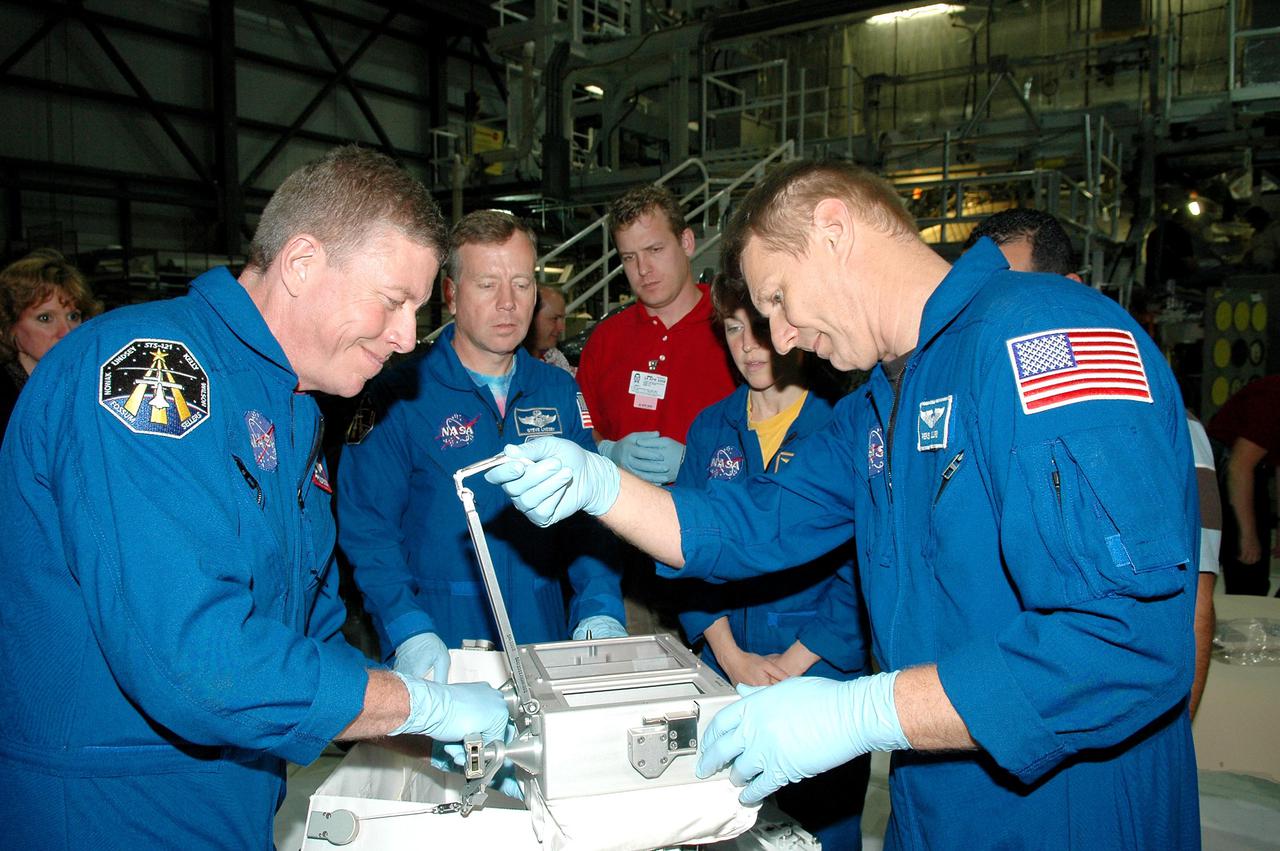 KENNEDY SPACE CENTER, FLA. - In the Orbiter Processing Facility at NASA’s Kennedy Space Center, astronauts of the second Return to Flight mission, STS-121, practice using the Tile Repair Kit. Crew members seen in this photo are, left to right, Mission Specialist Michael E. Fossum, Commander Steven W. Lindsey, and Mission Specialists Lisa Nowak and Piers J. Sellers. The crew is at KSC to participate in the Crew Equipment Interface Test (CEIT). During CEIT, the crew has an opportunity to get a hands-on look at the orbiter and equipment they will be working with on their missions. Mission STS-121 is scheduled to launch aboard Atlantis in July.