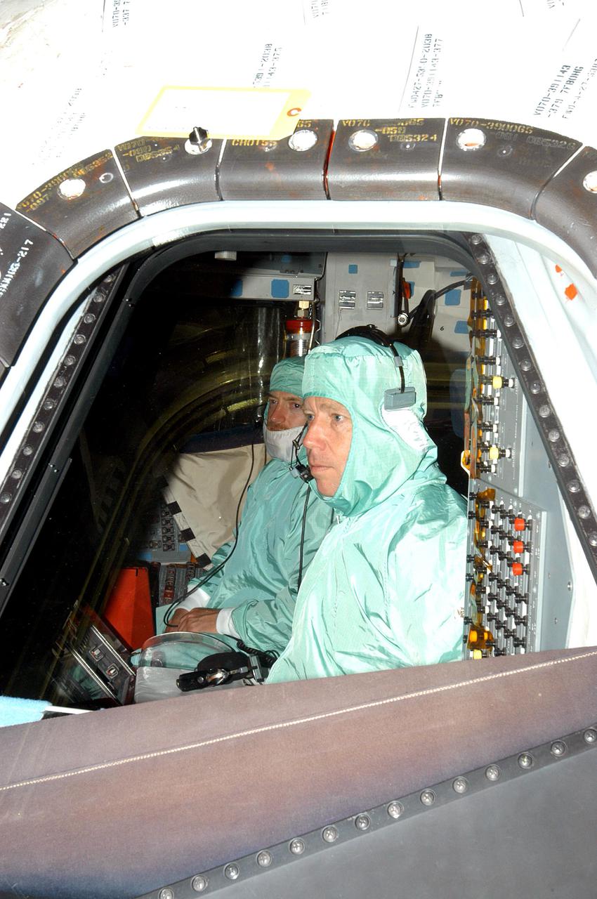KENNEDY SPACE CENTER, FLA.  -  In Orbiter Processing Facility bay 1, STS-121 Mission Commander Steven W. Lindsey (right) and Pilot Mark E. Kelly inspect the windows in Atlantis' cockpit. The STS-121 crew is at KSC to participate in the Crew Equipment Interface Test (CEIT). During CEIT, the crew has an opportunity to get a hands-on look at the orbiter and equipment they will be working with on their mission. STS-121, the second Return to Flight mission, is scheduled to launch aboard Atlantis in July.