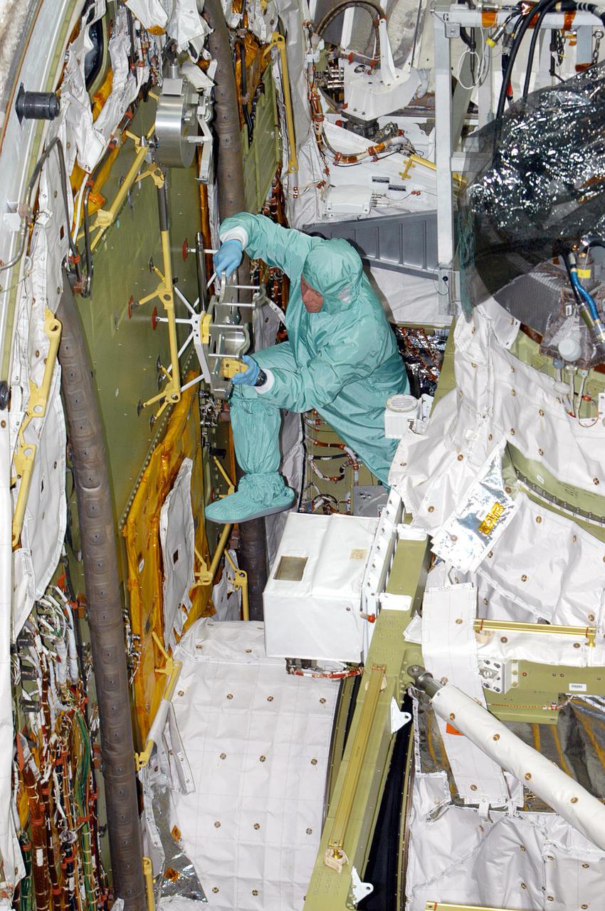 KENNEDY SPACE CENTER, FLA. - During Crew Equipment Interface Test (CEIT) in the Orbiter Processing Facility at NASA’s Kennedy Space Center, STS-121 Mission Specialist Michael E. Fossum familiarizes himself with the Portable Foot Restraint on the forward bulkhead of Atlantis. The Airlock is in the center. During CEIT, the crew has an opportunity to get a hands-on look at the orbiter and equipment they will be working with on their mission. Mission STS-121 is scheduled to launch aboard Space Shuttle Atlantis in July.