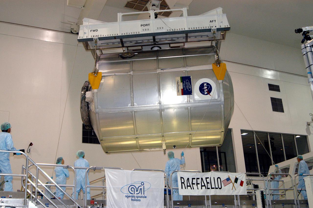 KENNEDY SPACE CENTER, FLA. - In the Space Station Processing Facility, workers stand by as the Multi-Purpose Logistics Module Raffaello is lifted off its stand.  Raffaello is being moved to the Payload Transportation Canister for installation and transfer to Launch Pad 39-B.  Raffaello will travel aboard Space Shuttle Discovery on Return to Flight Mission STS-114 to the International Space Station.  Raffaello will carry 12 racks of cargo to the Station, including food, clothing, spare parts and research equipment.  The Boeing Company,  a KSC and NASA prime contractor for ISS element processing, prepared Raffaello for flight.  The module was built by the Italian Space Agency for NASA under a cooperative space agreement.