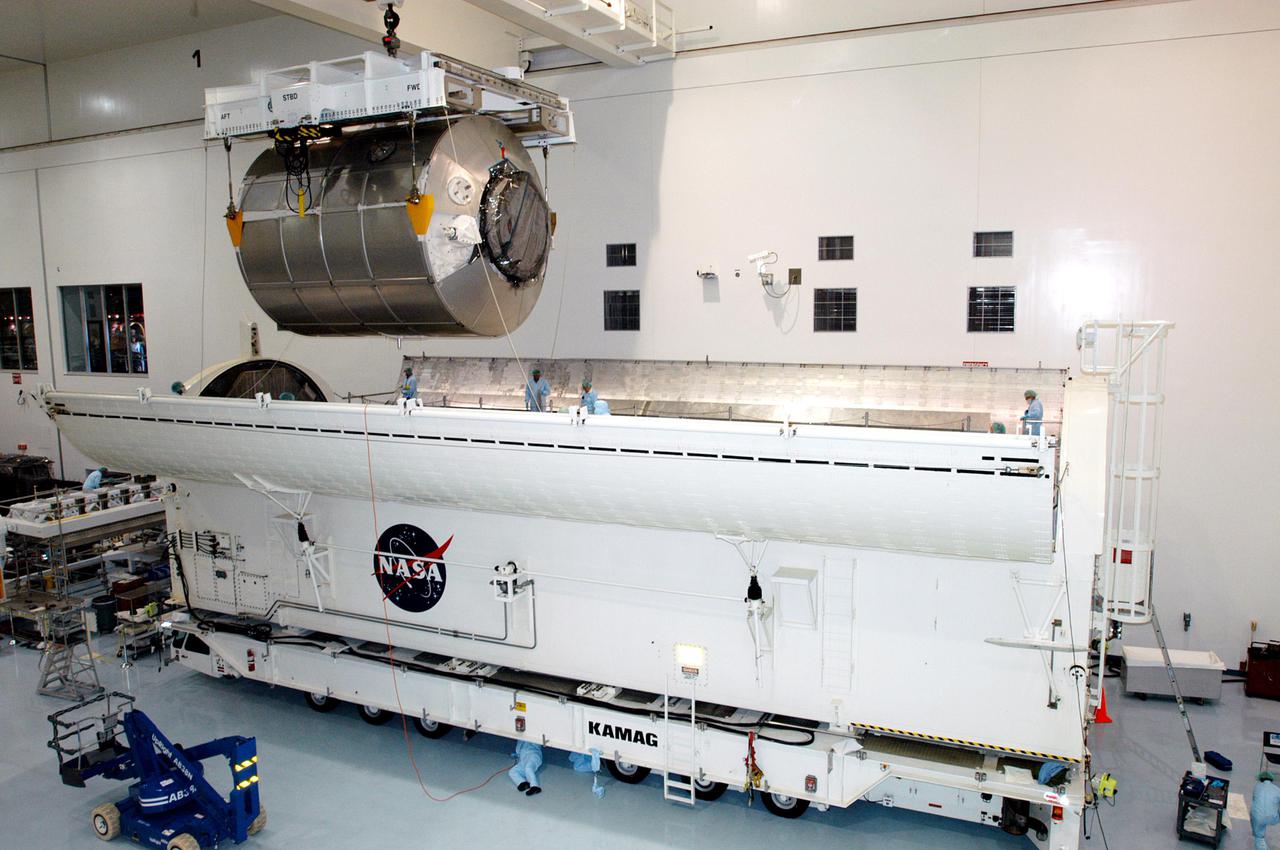KENNEDY SPACE CENTER, FLA. - In the Space Station Processing Facility, the Multi-Purpose Logistics Module Raffaello is lowered into the Payload Transportation Canister for installation and transfer to Launch Pad 39-B.  Raffaello will travel aboard Space Shuttle Discovery on Return to Flight Mission STS-114 to the International Space Station.  Raffaello will carry 12 racks of cargo to the Station, including food, clothing, spare parts and research equipment.  The Boeing Company,  a KSC and NASA prime contractor for ISS element processing, prepared Raffaello for flight.  The module was built by the Italian Space Agency for NASA under a cooperative space agreement.