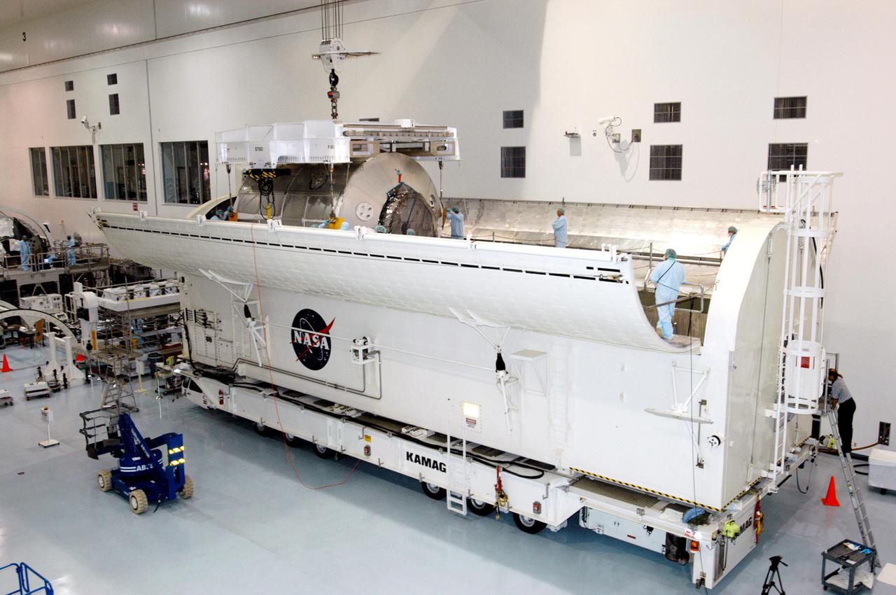 KENNEDY SPACE CENTER, FLA. - In the Space Station Processing Facility, the Multi-Purpose Logistics Module Raffaello is lowered into the Payload Transportation Canister for installation and transfer to Launch Pad 39-B.  Raffaello will travel aboard Space Shuttle Discovery on Return to Flight Mission STS-114 to the International Space Station.  Raffaello will carry 12 racks of cargo to the Station, including food, clothing, spare parts and research equipment.  The Boeing Company,  a KSC and NASA prime contractor for ISS element processing, prepared Raffaello for flight.  The module was built by the Italian Space Agency for NASA under a cooperative space agreement.