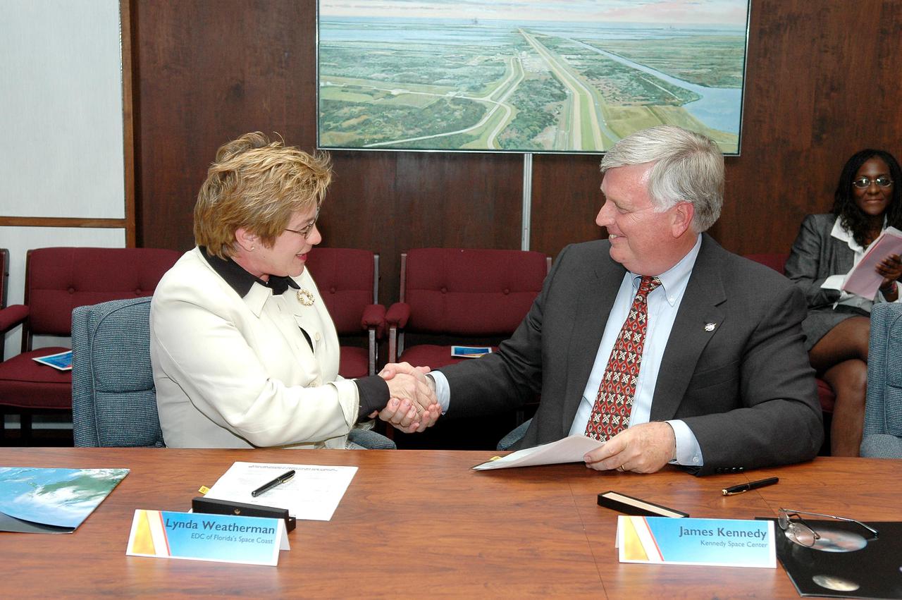 KENNEDY SPACE CENTER, FLA. - Lynda Weatherman, president and CEO of the Economic Development Commission of Florida’s Space Coast, and Jim Kennedy, director of Kennedy Space Center, congratulate each other after signing a three-year Space Act Agreement for economic development cooperation in support of existing and future missions of NASA at KSC. The agreement underscores business development strategies to ensure KSC and Brevard County continue to be competitive and develop space-related initiatives.