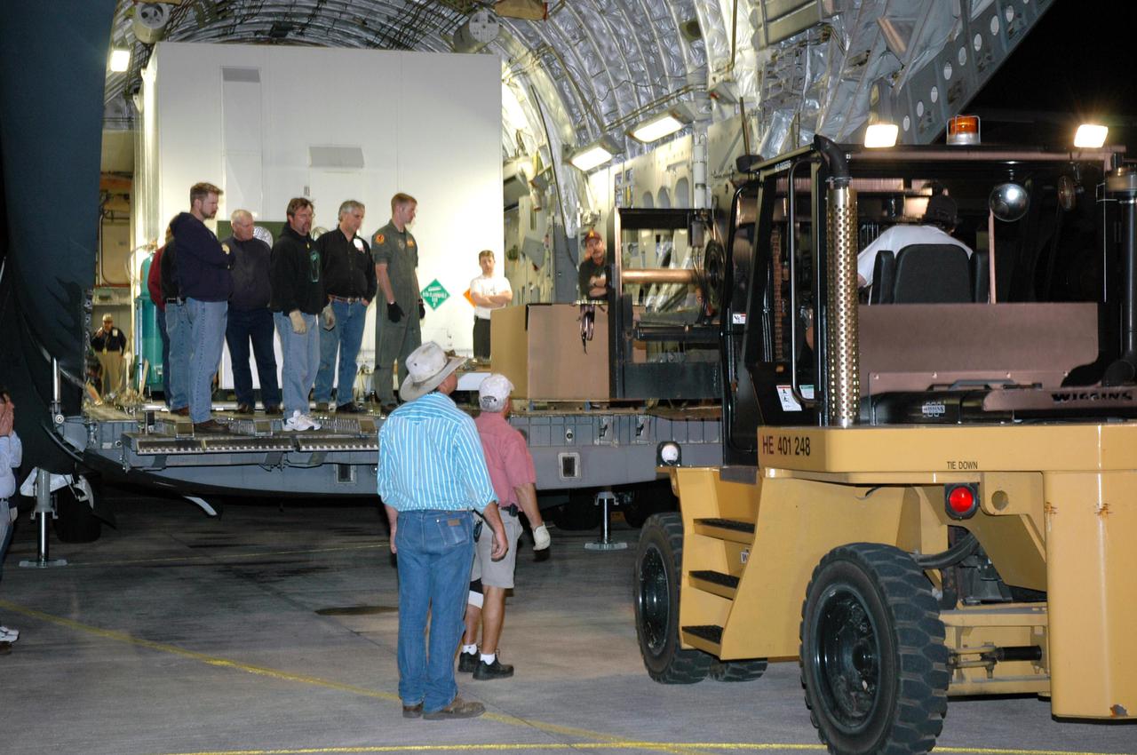 KENNEDY SPACE CENTER, FLA. - A forklift moves into place behind the Air Force C-17 cargo plane delivering the Mars Reconnaissance Orbiter (MRO) equipment to Kennedy Space Center's Shuttle Landing Facility. The MRO is being moved to the Payload Hazardous Servicing Facility. The MRO was built by Lockheed Martin for NASA's Jet Propulsion Laboratory in California. It is the next major step in Mars exploration and scheduled for launch from Cape Canaveral Air Force Station in a window opening Aug. 10. The MRO carries six primary instruments: the High Resolution Imaging Science Experiment, Context Camera, Mars Color Imager, Compact Reconnaissance Imaging Spectrometer for Mars, Mars Climate Sounder and Shallow Radar. By 2007, the MRO will begin a series of global mapping, regional survey and targeted observations from a near-polar, low-altitude Mars orbit. It will observe the atmosphere and surface of Mars while probing its shallow subsurface as part of a “follow the water” strategy.