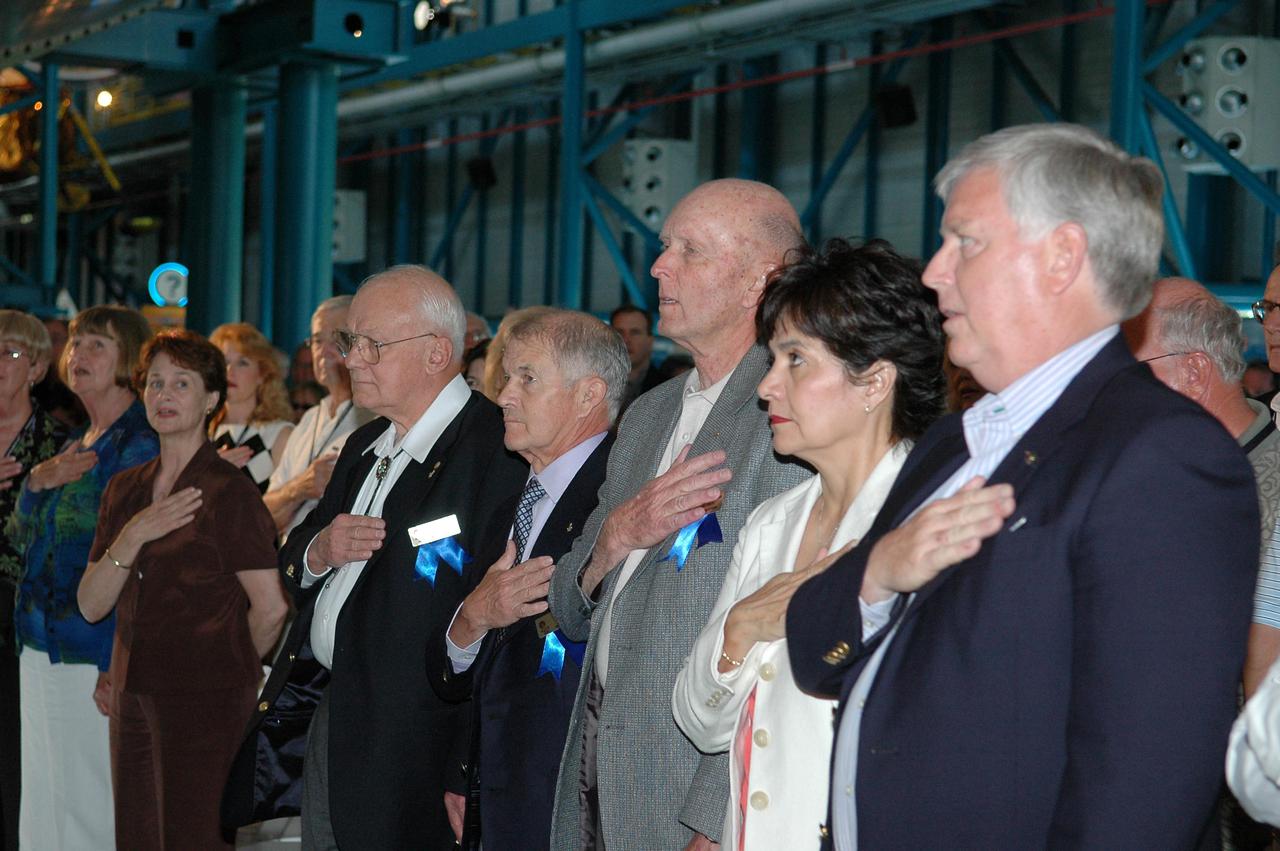 KENNEDY SPACE CENTER, FLA. -  At the Astronaut Hall of Fame Induction ceremony in Kennedy Space Center Visitor Complex’s Apollo_Saturn V Center, guests and audience recite the Pledge of Allegiance.   The new inductees, displaying blue ribbons, are Bruce McCandless (left to right), Joe Allen and Gordon Fullerton.  Next to them are Jim Kennedy (far right), who is director of Kennedy Space Center, and his wife, Bernadette.  Recognized for their individual flight accomplishments and contributions to the success and future success of the U.S. space program, this elite group of inductees is among only 60 astronauts to be honored in the Hall of Fame and the fourth group of Space Shuttle astronauts named.