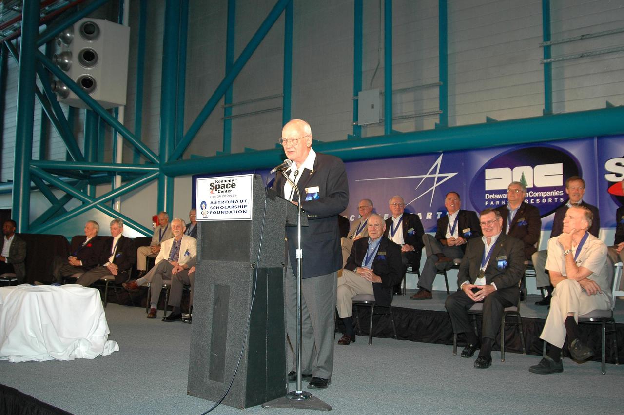 KENNEDY SPACE CENTER, FLA. -  At the Astronaut Hall of Fame Induction Ceremony, new inductee Bruce McCandless speaks to the guests. Seen behind him are current Hall of Famers (back row) Al Gordon, Walt Cunningham, Jack Lousma, Bill Pogue, Robert Crippen, Dan Brandenstein and Robert “Hoot” Gibson; (front row) Scott Carpenter, John  Young, Owen Garriott, Jim Lovell, Fred Haise and Vance Brand.  Garriott is chairman of the Astronaut Hall of Fame.  The other new inductees are Joe Allen and Gordon Fullerton.  The event is being held in the Kennedy Space Center Visitor Complex’s Apollo_Saturn V Center.  Recognized for their individual flight accomplishments and contributions to the success and future success of the U.S. space program, this elite group of inductees is among only 60 astronauts to be honored in the Hall of Fame and the fourth group of Space Shuttle astronauts named.