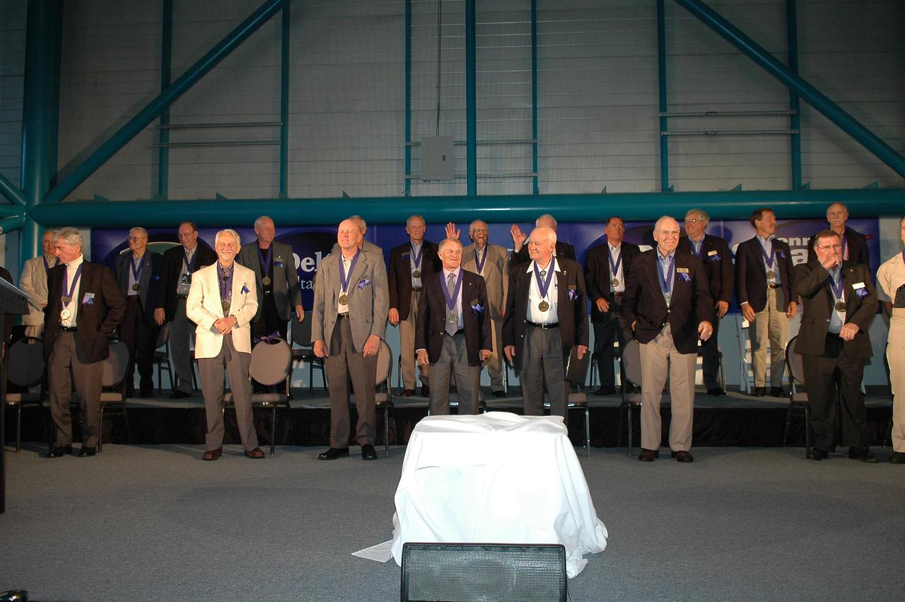 KENNEDY SPACE CENTER, FLA. -  Members of the Astronaut Hall of Fame are applauded by the guests at the Astronaut Hall of Fame Induction Ceremony held at the Kennedy Space Center Visitor Complex’s Apollo_Saturn V Center.  From left are Al Gordon, John Young, Walt Cunningham, Bill Anders, Owen Garriott, Ed Mitchell, Gordon Fullerton, Al Worden, Charlie Duke, Joe Allen, Jack Lousma, Bruce McCandless, Bill Pogue, Robert Crippen, Jim Lovell, Dan Brandenstein, Robert “Hoot” Gibson, Fred Haise, and Stephen Covey.  Not pictured are Scott Carpenter and Vance Brand.  McCandless, Allen and Fullerton are the 2005 inductees.  Recognized for their individual flight accomplishments and contributions to the success and future success of the U.S. space program, this elite group of inductees is among only 60 astronauts to be honored in the Hall of Fame and the fourth group of Space Shuttle astronauts named.