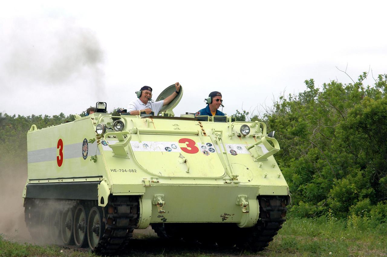 KENNEDY SPACE CENTER, FLA. - During Terminal Countdown Demonstration Test (TCDT) activities at NASA’s Kennedy Space Center, STS-114 Mission Specialist Stephen Robinson (right) practices driving an M-113, an armored personnel carrier that is used for speedy departure from the launch pad in an emergency. At left is Capt. George Hoggard, who is astronaut rescue team leader. The TCDT is held at KSC prior to each Space Shuttle flight. It provides the crew of each mission an opportunity to participate in simulated countdown activities. The test ends with a mock launch countdown culminating in a simulated main engine cutoff. The crew also spends time undergoing emergency egress training exercises at the launch pad. STS-114 is the first Return to Flight mission to the International Space Station. The launch window extends July 13 through July 31.
