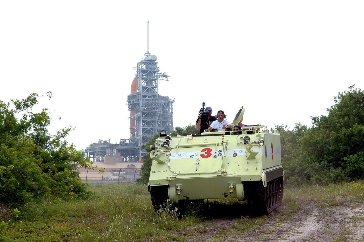 KENNEDY SPACE CENTER, FLA. - During Terminal Countdown Demonstration Test (TCDT) activities at NASA’s Kennedy Space Center, STS-114 Commander Eileen Collins takes her turn at driving an M-113, an armored personnel carrier that is used for speedy departure from the launch pad in an emergency. Standing behind her is Capt. George Hoggard, who is astronaut rescue team leader. On the left is KSC videographer Glen Benson. The TCDT is held at KSC prior to each Space Shuttle flight. It provides the crew of each mission an opportunity to participate in simulated countdown activities. The test ends with a mock launch countdown culminating in a simulated main engine cutoff. The crew also spends time undergoing emergency egress training exercises at the launch pad. STS-114 is the first Return to Flight mission to the International Space Station. The launch window extends July 13 through July 31.