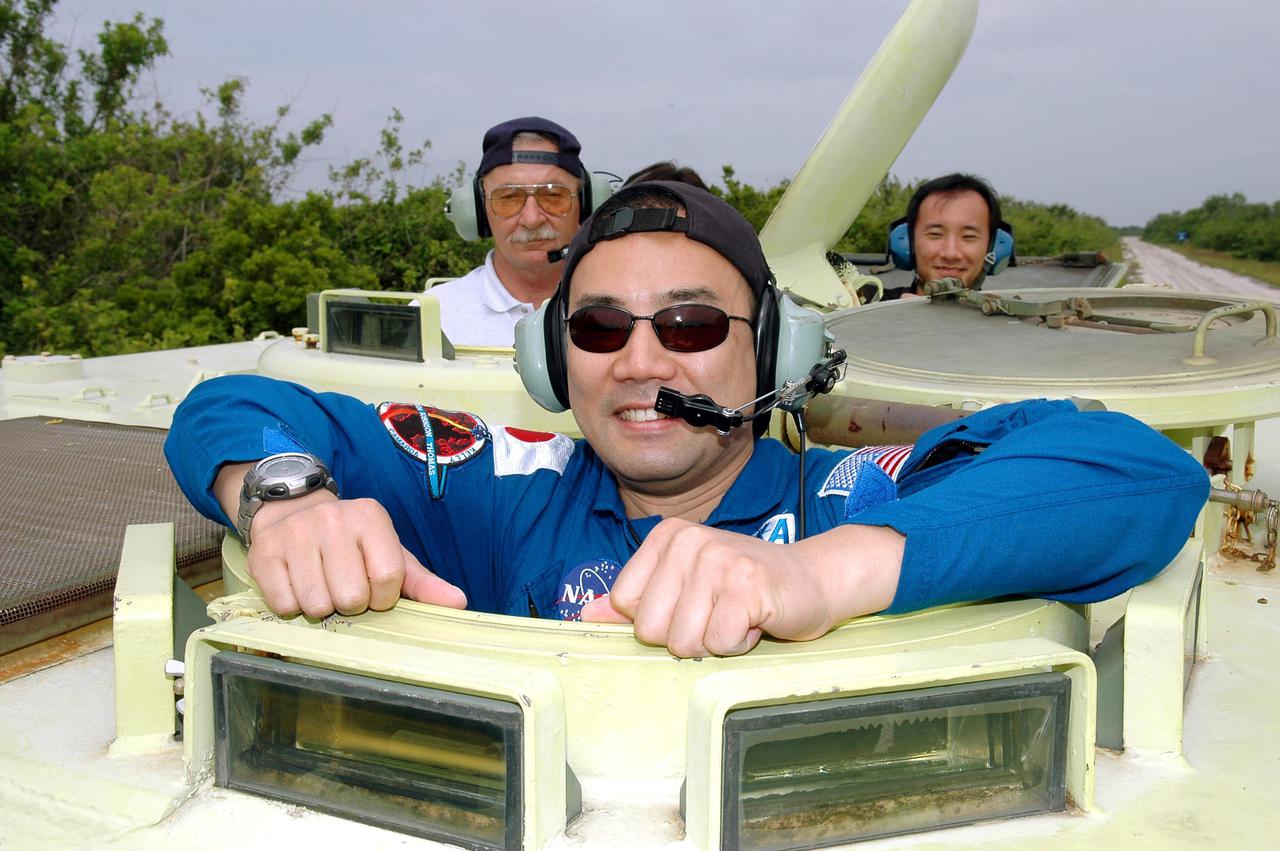 KENNEDY SPACE CENTER, FLA. - During Terminal Countdown Demonstration Test (TCDT) activities at NASA’s Kennedy Space Center, STS-114 Mission Specialist Soichi Noguchi is ready to practice driving an M-113, an armored personnel carrier that is used for speedy departure from the launch pad in an emergency. Behind him at left is Capt. George Hoggard, who is astronaut rescue team leader. Noguchi is with the Japan Aerospace Exploration Agency.The TCDT is held at KSC prior to each Space Shuttle flight. It provides the crew of each mission an opportunity to participate in simulated countdown activities. The test ends with a mock launch countdown culminating in a simulated main engine cutoff. The crew also spends time undergoing emergency egress training exercises at the launch pad. STS-114 is the first Return to Flight mission to the International Space Station. The launch window extends July 13 through July 31.