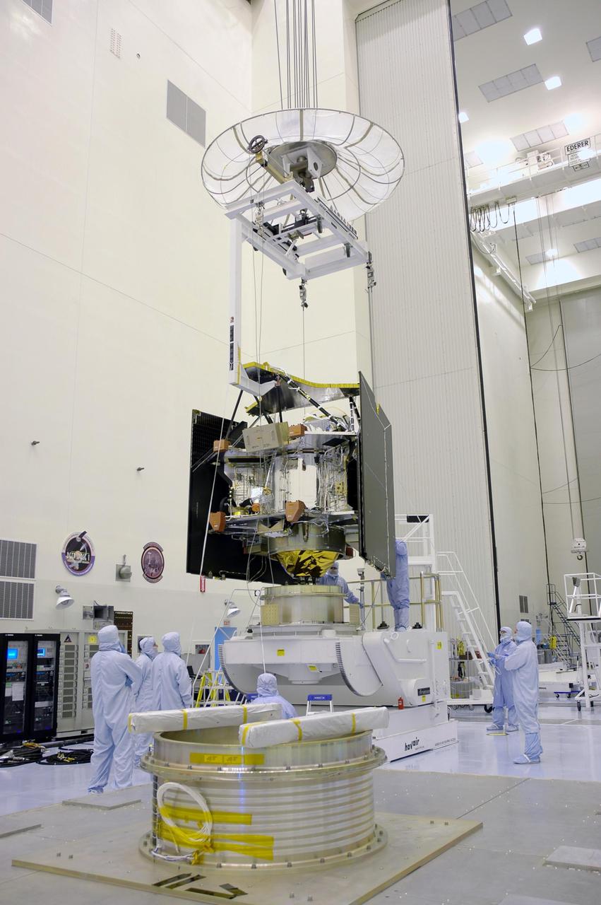 KENNEDY SPACE CENTER, FLA. - In a clean room inside the Payload Hazardous Servicing Facility (PHSF) at NASA’s Kennedy Space Center, the suspended Mars Reconnaissance Orbiter (MRO) nears the workstand in the background for final assembly and testing. In the PHSF, the spacecraft will undergo multiple mechanical assembly operations and electrical tests to verify its readiness for launch. A test this month will verify the spacecraft’s ability to communicate through NASA's Deep Space Network tracking stations. A June test will check the deployment of the spacecraft's high gain communications antenna. Another major deployment test will check out the spacecraft's large solar arrays. The MRO was built for NASA’s Jet Propulsion Laboratory in California. It is the next major step in Mars exploration and scheduled for launch from Cape Canaveral Air Force Station in a window opening Aug. 10. The MRO is an important next step in fulfilling NASA’s vision of space exploration and ultimately sending human explorers to Mars and beyond.