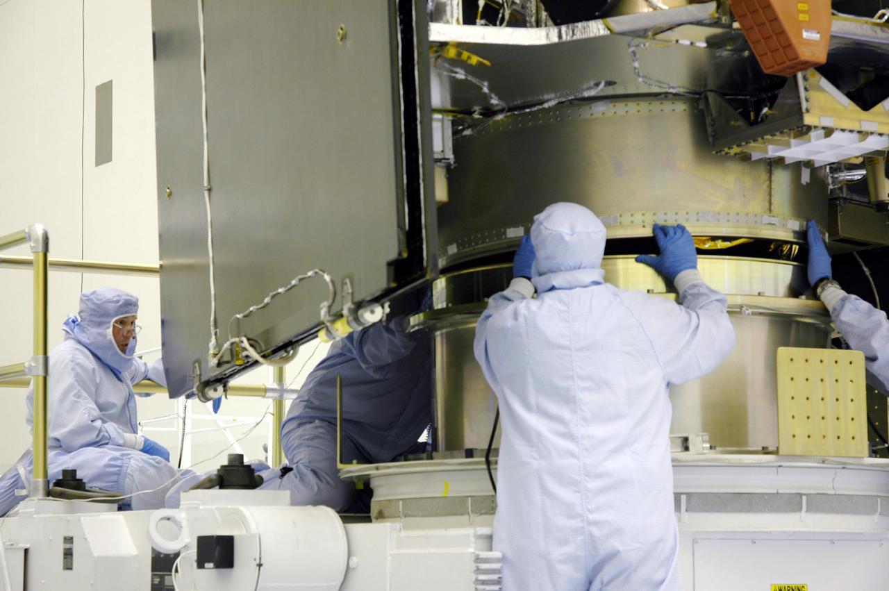 KENNEDY SPACE CENTER, FLA. - In a clean room inside the Payload Hazardous Servicing Facility (PHSF) at NASA's Kennedy Space Center, Lockheed Martin workers help guide the Mars Reconnaissance Orbiter onto the workstand for final assembly and testing. In the PHSF, the spacecraft will undergo multiple mechanical assembly operations and electrical tests to verify its readiness for launch. A test this month will verify the spacecraft's ability to communicate through NASA's Deep Space Network tracking stations. A June test will check the deployment of the spacecraft's high gain communications antenna. Another major deployment test will check out the spacecraft's large solar arrays. The MRO was built for NASA's Jet Propulsion Laboratory in California. It is the next major step in Mars exploration and scheduled for launch from Cape Canaveral Air Force Station in a window opening Aug. 10. The MRO is an important next step in fulfilling NASA's vision of space exploration and ultimately sending human explorers to Mars and beyond.