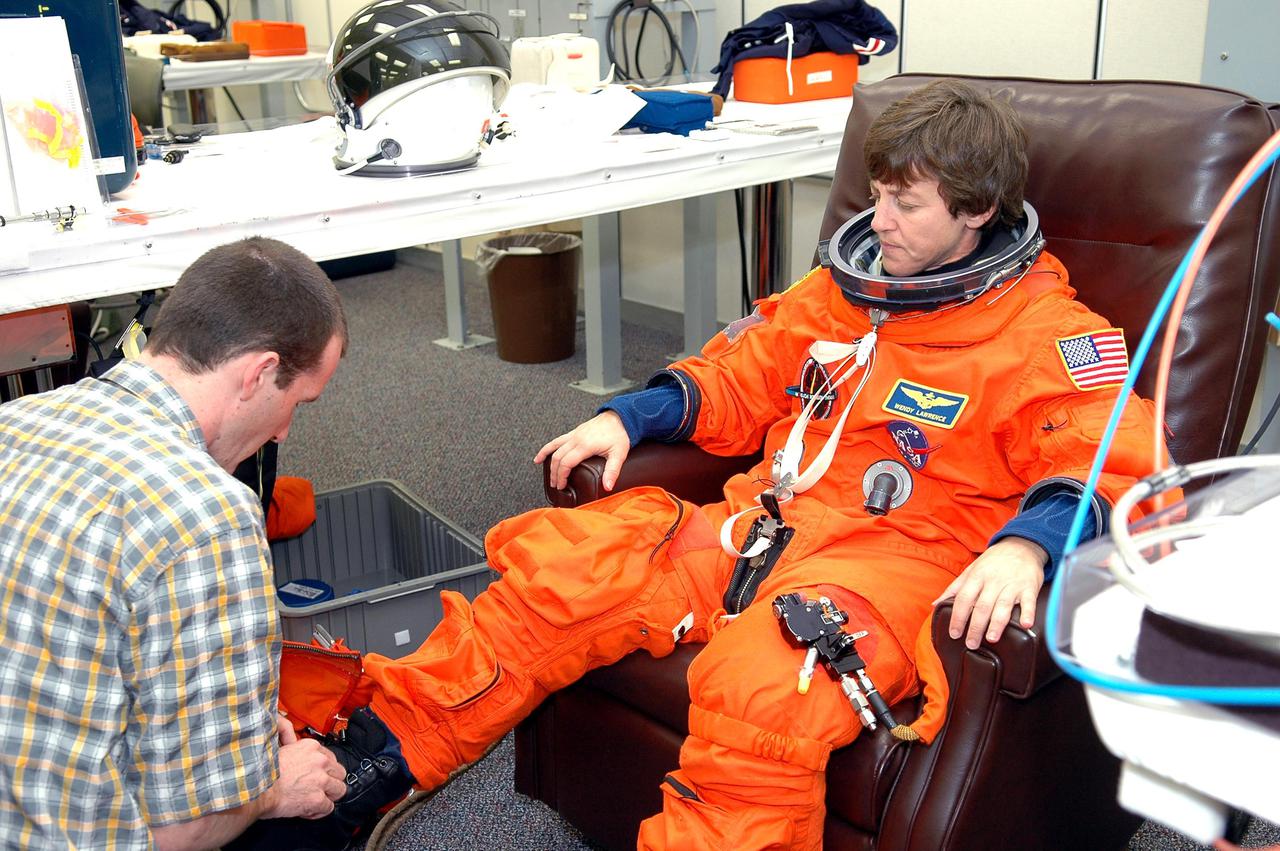 KENNEDY SPACE CENTER, FLA. - As part of pre-pack and fit check for Terminal Countdown Demonstration Test (TCDT) activities, STS-114 Mission Specialist Wendy Lawrence has her boot checked. The TCDT is held at KSC prior to each Space Shuttle flight. It provides the crew of each mission an opportunity to participate in simulated countdown activities. The test ends with a mock launch countdown culminating in a simulated main engine cutoff. The crew also spends time undergoing emergency egress training exercises at the launch pad. STS-114 is the first Return to Flight mission to the International Space Station. The launch window extends July 13 through July 31.