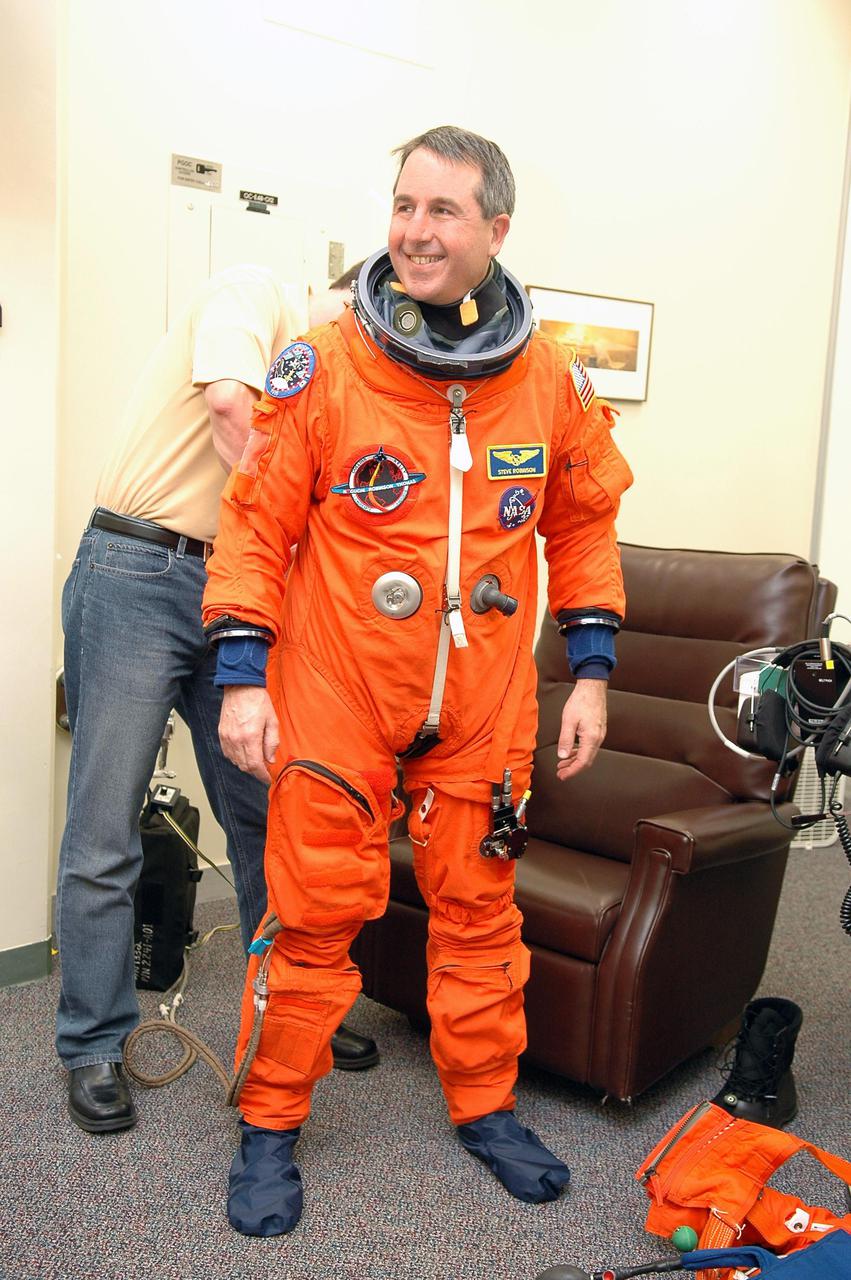 KENNEDY SPACE CENTER, FLA. - As part of pre-pack and fit check for Terminal Countdown Demonstration Test (TCDT) activities, STS-114 Mission Specialist Stephen Robinson has his launch suit checked for fit. The TCDT is held at KSC prior to each Space Shuttle flight. It provides the crew of each mission an opportunity to participate in simulated countdown activities. The test ends with a mock launch countdown culminating in a simulated main engine cutoff. The crew also spends time undergoing emergency egress training exercises at the launch pad. STS-114 is the first Return to Flight mission to the International Space Station. The launch window extends July 13 through July 31.