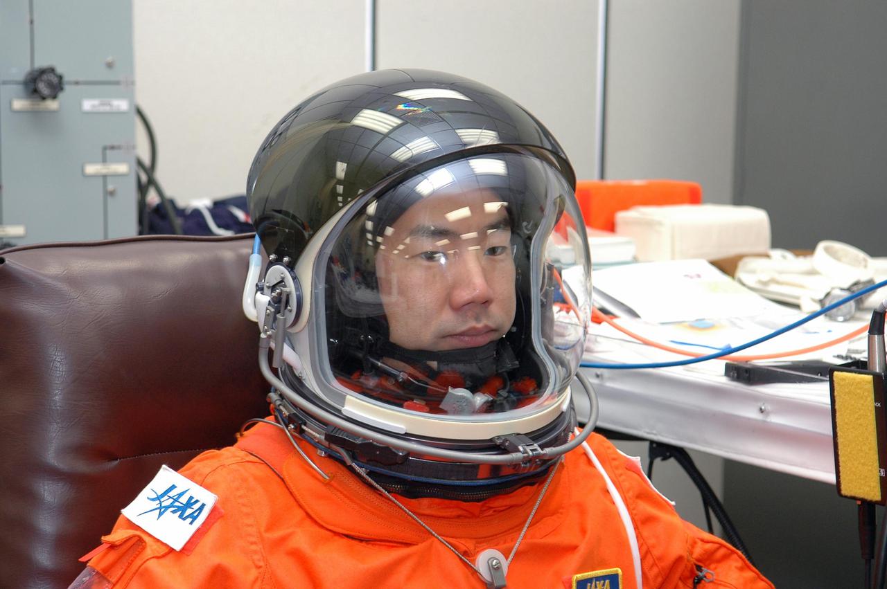KENNEDY SPACE CENTER, FLA. - As part of pre-pack and fit check for Terminal Countdown Demonstration Test (TCDT) activities, STS-114 Mission Specialist Soichi Noguchi tries on his helmet. The TCDT is held at KSC prior to each Space Shuttle flight. It provides the crew of each mission an opportunity to participate in simulated countdown activities. The test ends with a mock launch countdown culminating in a simulated main engine cutoff. The crew also spends time undergoing emergency egress training exercises at the launch pad. STS-114 is the first Return to Flight mission to the International Space Station. The launch window extends July 13 through July 31.
