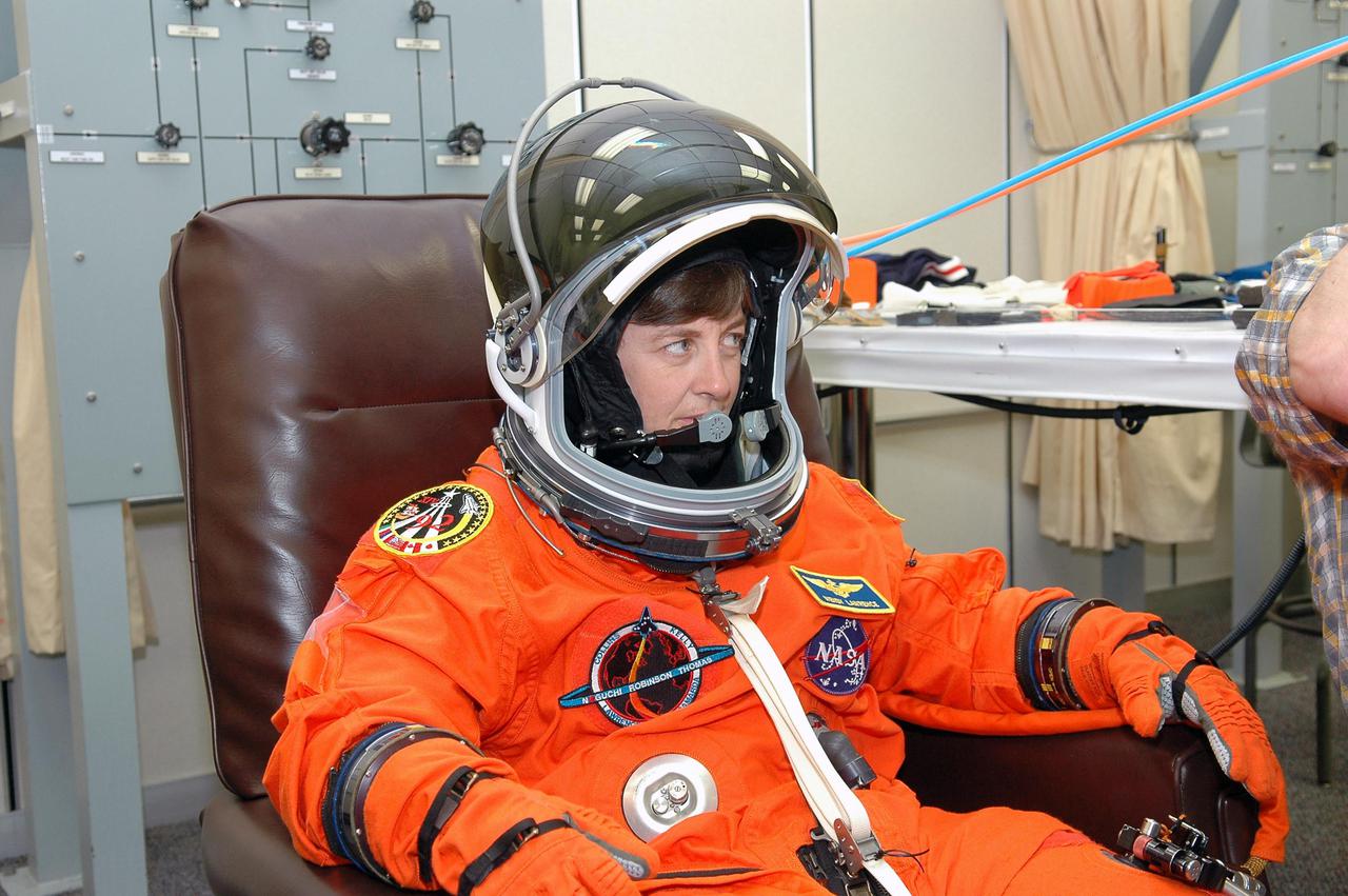 KENNEDY SPACE CENTER, FLA. - As part of pre-pack and fit check for Terminal Countdown Demonstration Test (TCDT) activities, STS-114 Mission Specialist Wendy Lawrence tries on her helmet. The TCDT is held at KSC prior to each Space Shuttle flight. It provides the crew of each mission an opportunity to participate in simulated countdown activities. The test ends with a mock launch countdown culminating in a simulated main engine cutoff. The crew also spends time undergoing emergency egress training exercises at the launch pad. STS-114 is the first Return to Flight mission to the International Space Station. The launch window extends July 13 through July 31.