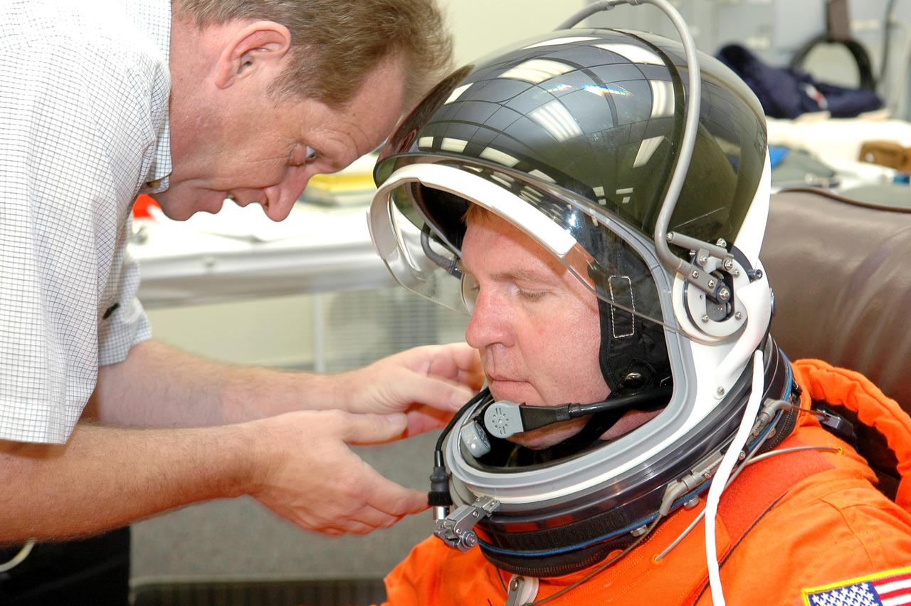KENNEDY SPACE CENTER, FLA. - As part of pre-pack and fit check for Terminal Countdown Demonstration Test (TCDT) activities, STS-114 Mission Specialist Andrew Thomas tries on his helmet. The TCDT is held at KSC prior to each Space Shuttle flight. It provides the crew of each mission an opportunity to participate in simulated countdown activities. The test ends with a mock launch countdown culminating in a simulated main engine cutoff. The crew also spends time undergoing emergency egress training exercises at the launch pad. STS-114 is the first Return to Flight mission to the International Space Station. The launch window extends July 13 through July 31.