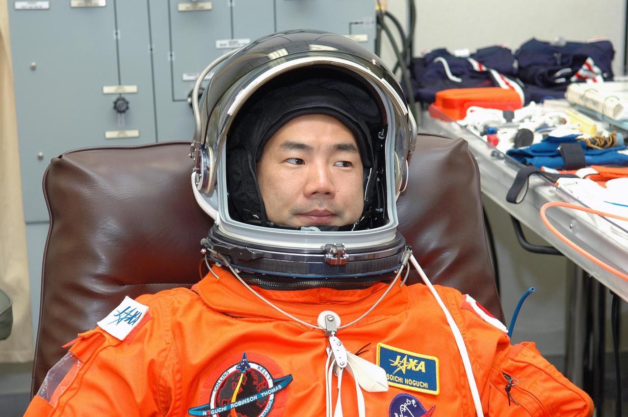 KENNEDY SPACE CENTER, FLA. - As part of pre-pack and fit check for Terminal Countdown Demonstration Test (TCDT) activities, STS-114 Mission Specialist Soichi Noguchi tries on his helmet. The TCDT is held at KSC prior to each Space Shuttle flight. It provides the crew of each mission an opportunity to participate in simulated countdown activities. The test ends with a mock launch countdown culminating in a simulated main engine cutoff. The crew also spends time undergoing emergency egress training exercises at the launch pad. STS-114 is the first Return to Flight mission to the International Space Station. The launch window extends July 13 through July 31.