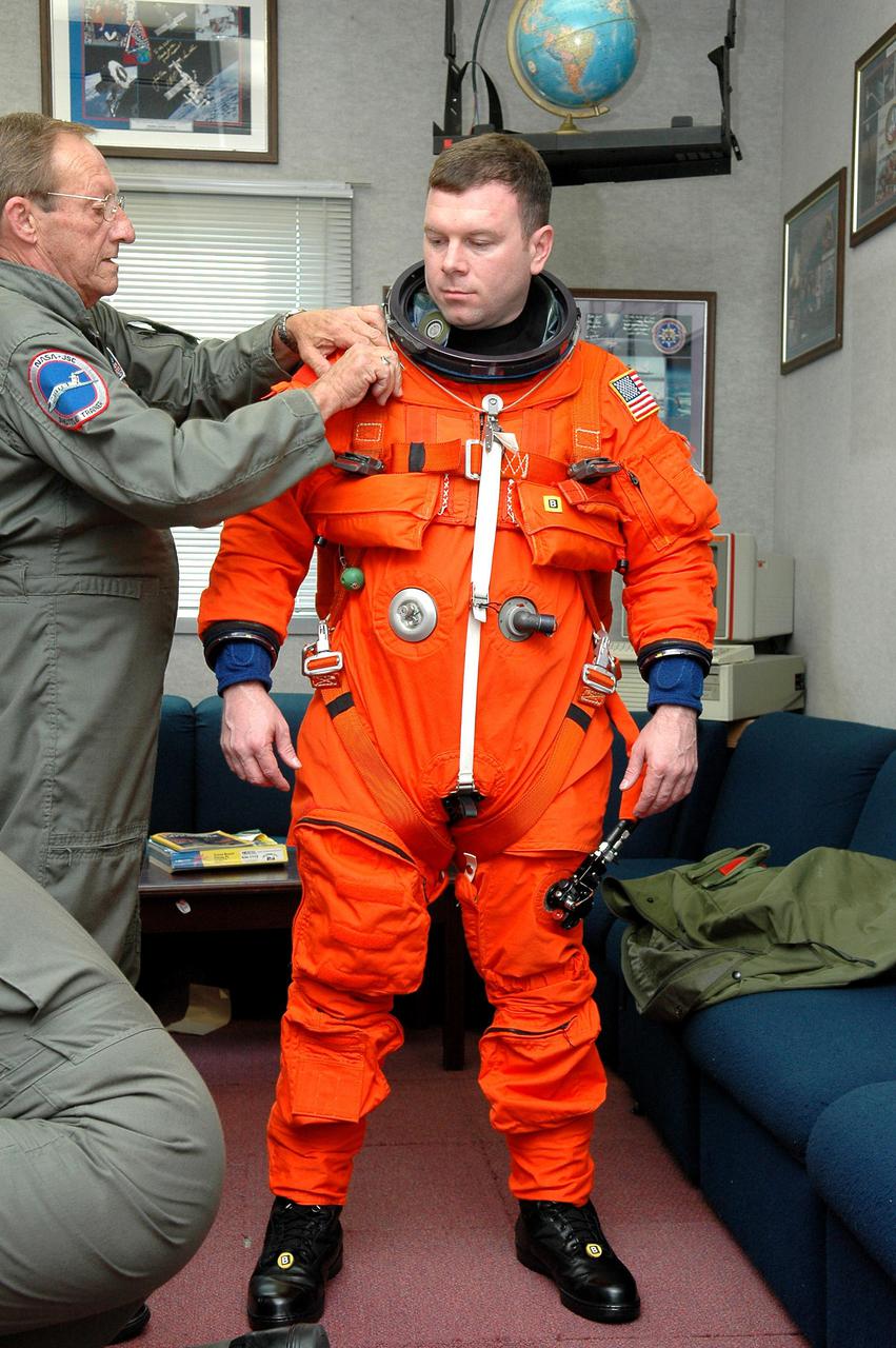 KENNEDY SPACE CENTER, FLA. -  STS-114 Pilot James Kelly suits up for practice flights on a Shuttle Training Aircraft (STA) used by Shuttle flight crews to practice landing the orbiter.  The STA is a modified Grumman American Aviation-built Gulfstream II executive jet that was modified to simulate an orbiter’s cockpit, motion and visual cues, and handling qualities.  In flight, the STA duplicates the orbiter’s atmospheric descent trajectory from approximately 35,000 feet altitude to landing on a runway. The orbiter differs in at least one major aspect from conventional aircraft; it is unpowered during re-entry and landing so its high-speed glide must be perfectly executed the first time. There is no go-around capability. The orbiter touchdown speed is 213 to 226 miles per hour. There are two STAs, based in Houston. STS-114 is the first Return to Flight mission, scheduled to launch July 13 in a window that extends through July 31.
