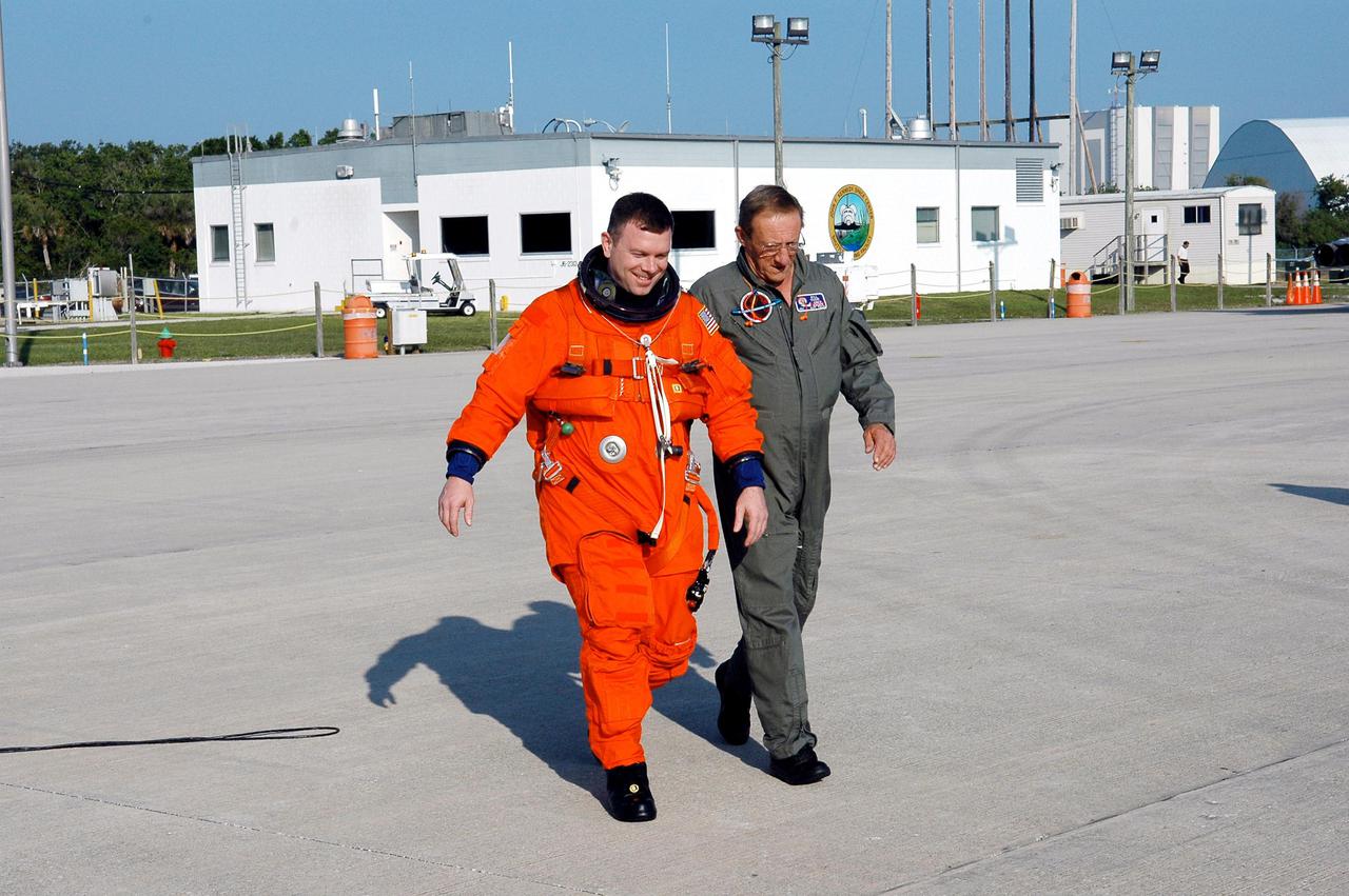 KENNEDY SPACE CENTER, FLA. -  STS-114 Pilot James Kelly walks across the Shuttle Landing Facility to a Shuttle Training Aircraft (STA) to practice landing the orbiter.    The STA is a modified Grumman American Aviation-built Gulfstream II executive jet that was modified to simulate an orbiter’s cockpit, motion and visual cues, and handling qualities.  In flight, the STA duplicates the orbiter’s atmospheric descent trajectory from approximately 35,000 feet altitude to landing on a runway. The orbiter differs in at least one major aspect from conventional aircraft; it is unpowered during re-entry and landing so its high-speed glide must be perfectly executed the first time. There is no go-around capability. The orbiter touchdown speed is 213 to 226 miles per hour. There are two STAs, based in Houston. STS-114 is the first Return to Flight mission, scheduled to launch July 13 in a window that extends through July 31.