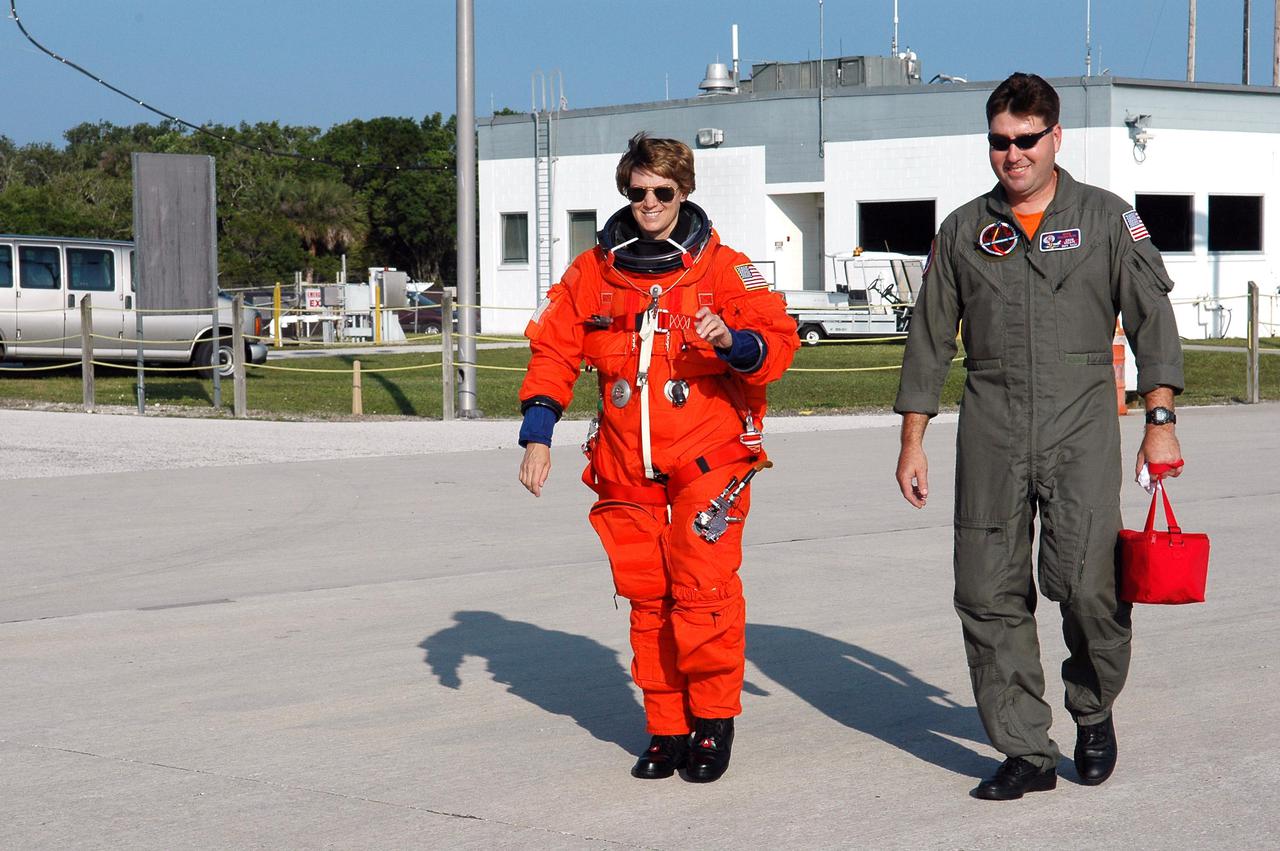 KENNEDY SPACE CENTER, FLA. -  STS-114 Commander Eileen Collins walks across the Shuttle Landing Facility to a Shuttle Training Aircraft (STA) to practice landing the orbiter.  The STA is a modified Grumman American Aviation-built Gulfstream II executive jet that was modified to simulate an orbiter’s cockpit, motion and visual cues, and handling qualities.  In flight, the STA duplicates the orbiter’s atmospheric descent trajectory from approximately 35,000 feet altitude to landing on a runway. The orbiter differs in at least one major aspect from conventional aircraft; it is unpowered during re-entry and landing so its high-speed glide must be perfectly executed the first time. There is no go-around capability. The orbiter touchdown speed is 213 to 226 miles per hour. There are two STAs, based in Houston. STS-114 is the first Return to Flight mission, scheduled to launch July 13 in a window that extends through July 31.