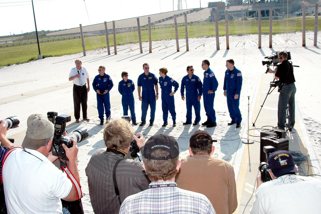 KENNEDY SPACE CENTER, FLA. -   The STS-114 crew gathers for media questions at the slidewire basket landing area on Launch Pad 39B.  Monitored by NASA Public Affairs Officer George Diller (at left with microphone), members of the crew are, from left, Mission Specialists Andrew Thomas, Wendy Lawrence and Stephen Robinson, Commander Eileen Collins, Mission Specialists Charles Camarda and Soichi Noguchi, and Pilot James Kelly. Noguchi is with the Japan Aerospace Exploration Agency.   The crew is at KSC for Terminal Countdown Demonstration Test (TCDT) activities.  The TCDT is held at KSC prior to each Space Shuttle flight. It provides the crew of each mission an opportunity to participate in simulated countdown activities. The test ends with a mock launch countdown culminating in a simulated main engine cutoff. The crew also spends time undergoing emergency egress training exercises at the launch pad.  STS-114 is designated the first Return to Flight mission, with a launch window extending from July 13 to July 31.